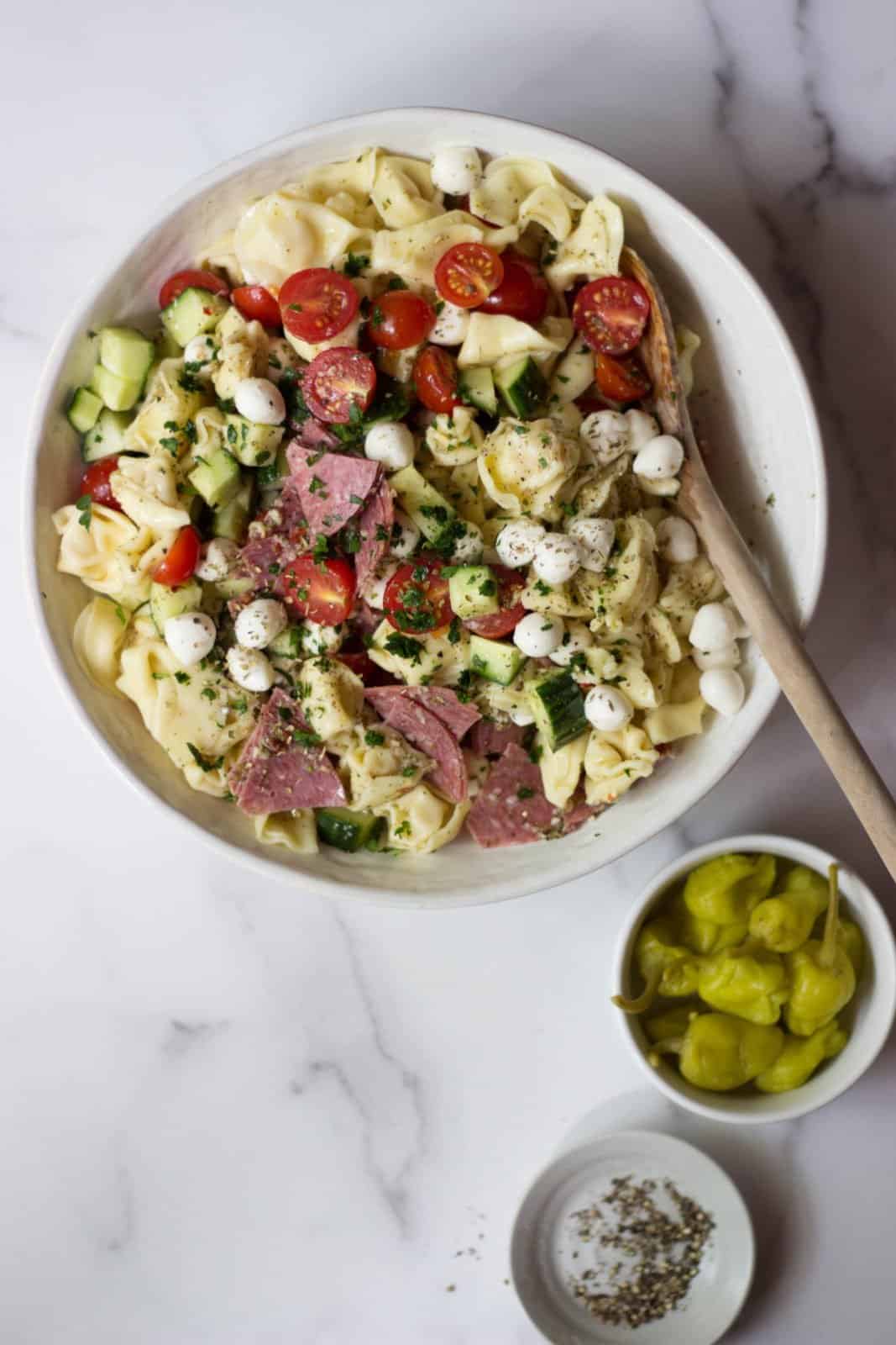 Overhead shot of Italian Tortellini Salad in a white serving bowl