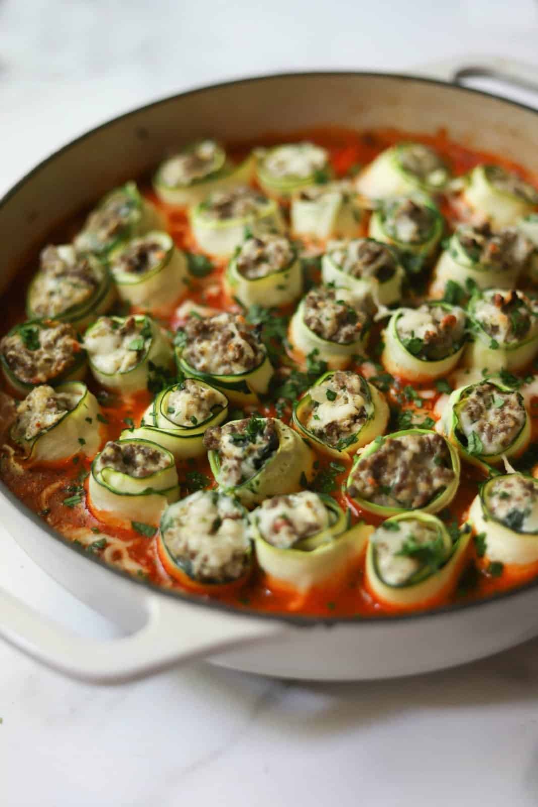 Ricotta & Beef Zucchini Roll-Ups in a white pan that's healthy and made in one pot. 