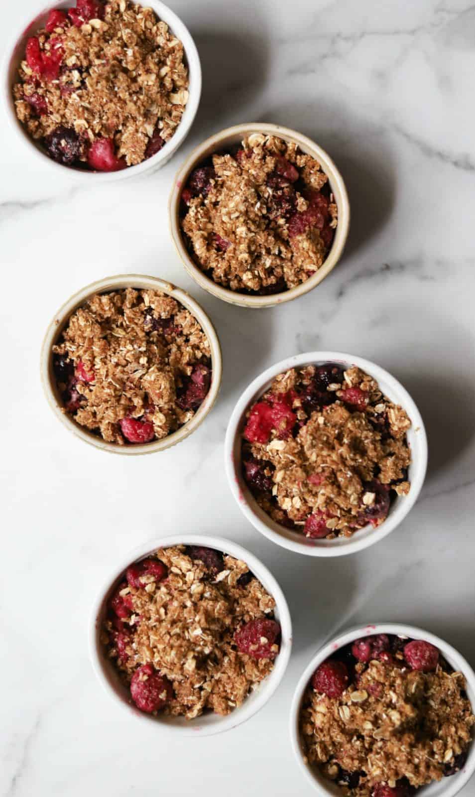 Mixed berry crisp in white ramekins