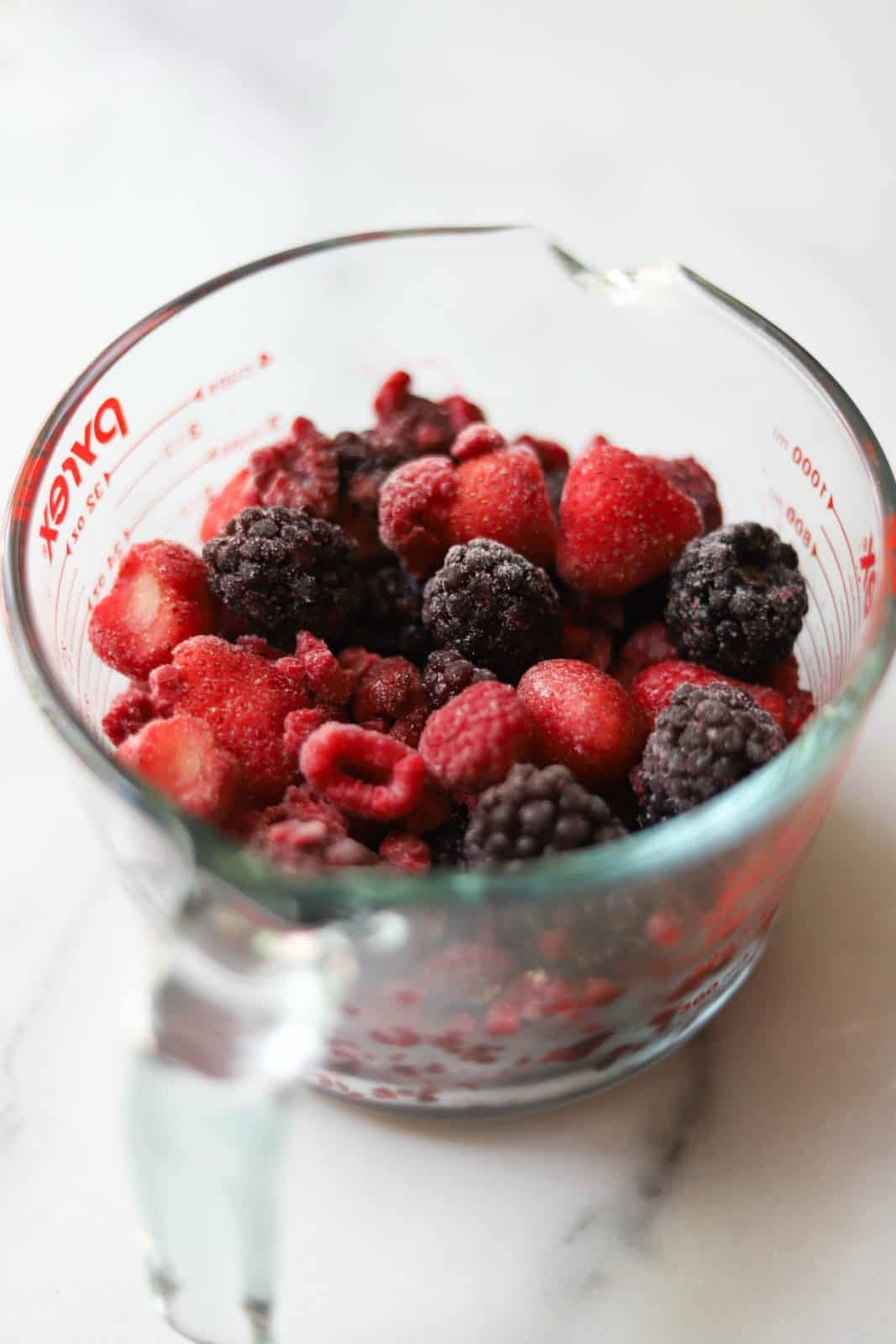 Mixed berries in a measuring cup
