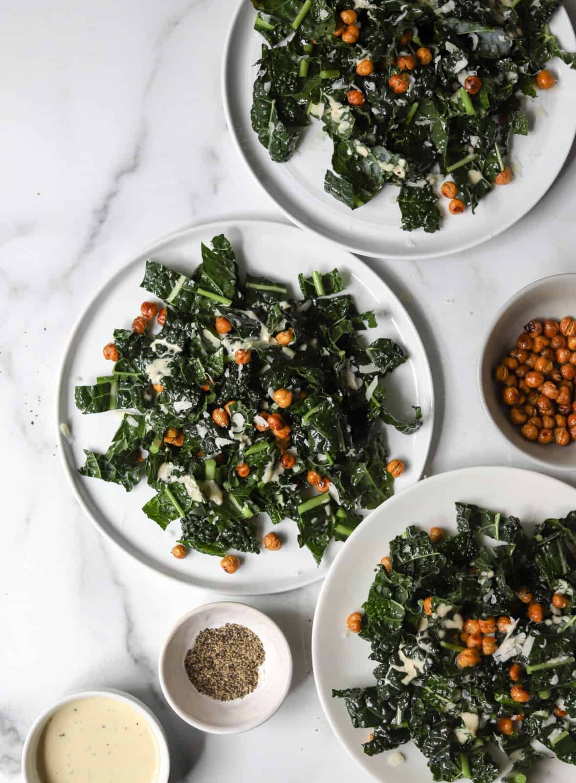 Plates of kale caesar salad with crispy chickpeas.