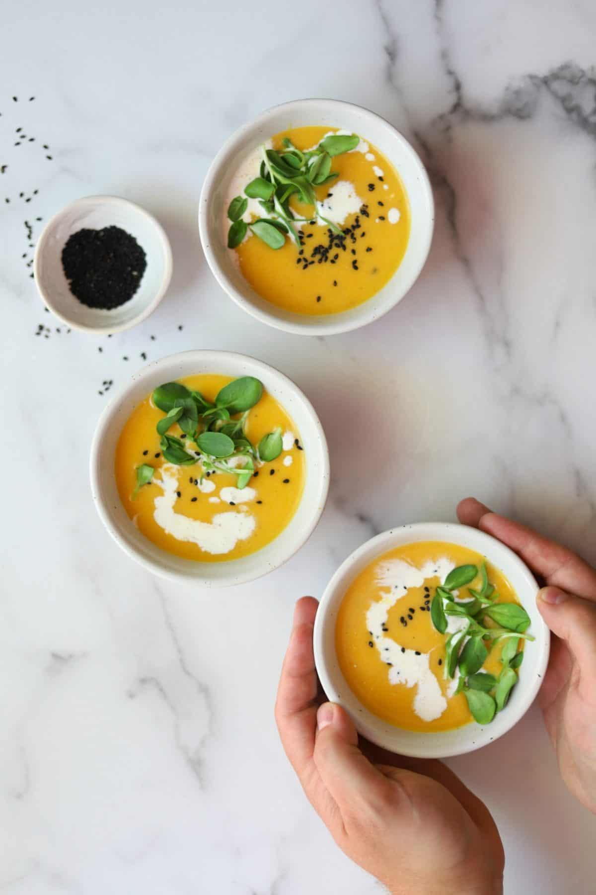 Butternut squash apple soup in white bowls