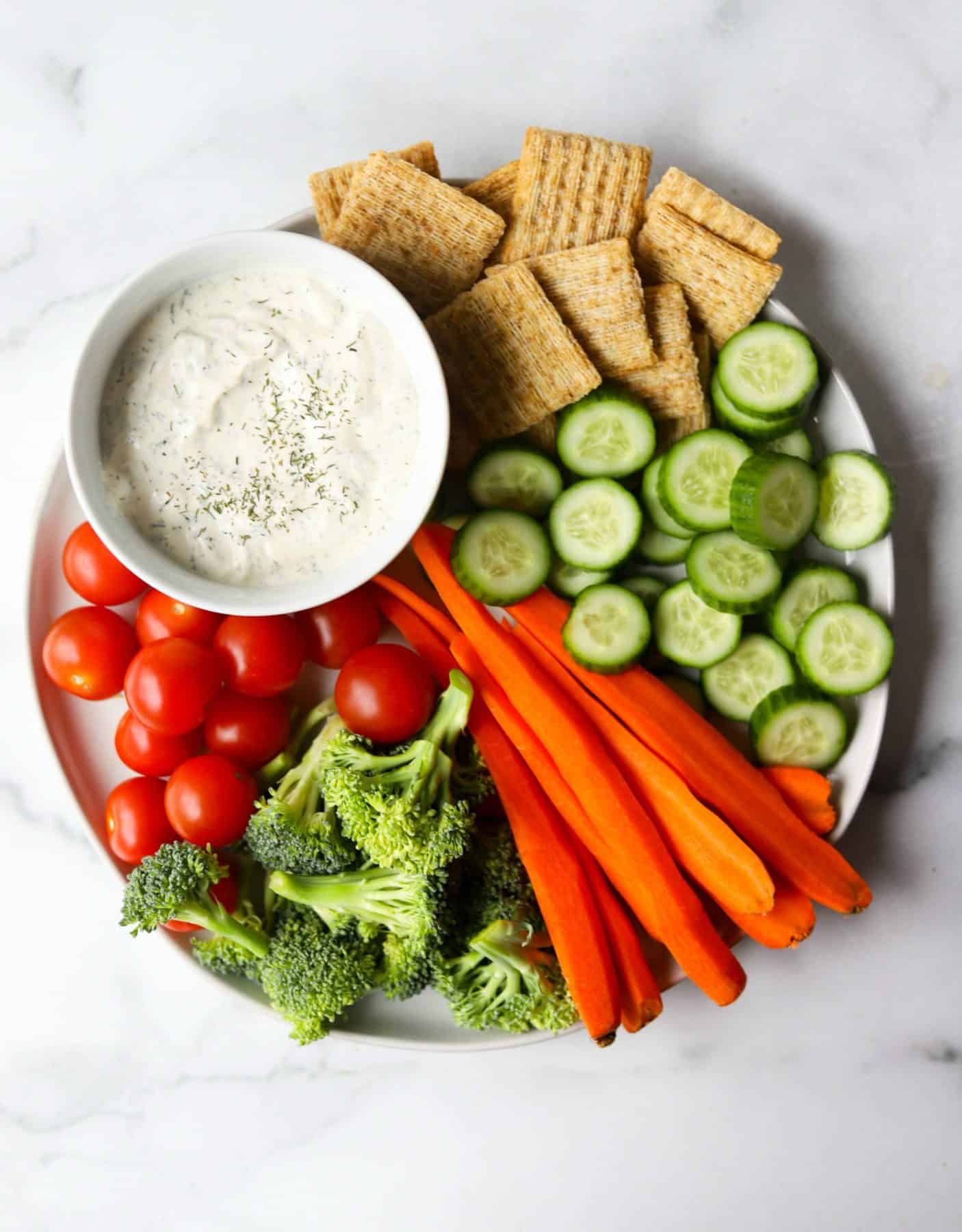 Veggie tray on white marble backdrop as an example of an easy way to eat more vegetables