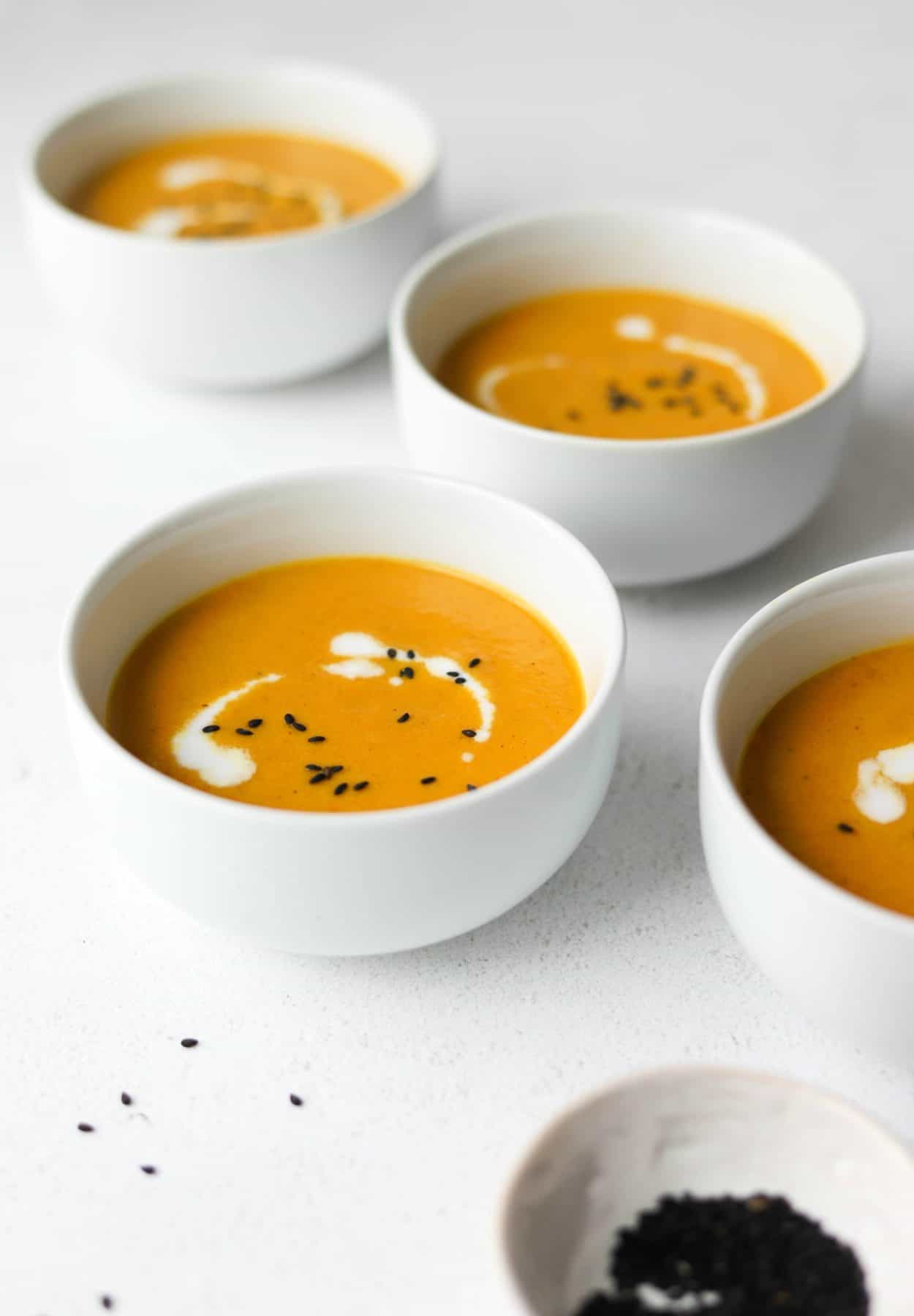 Carrot ginger soup in white bowls