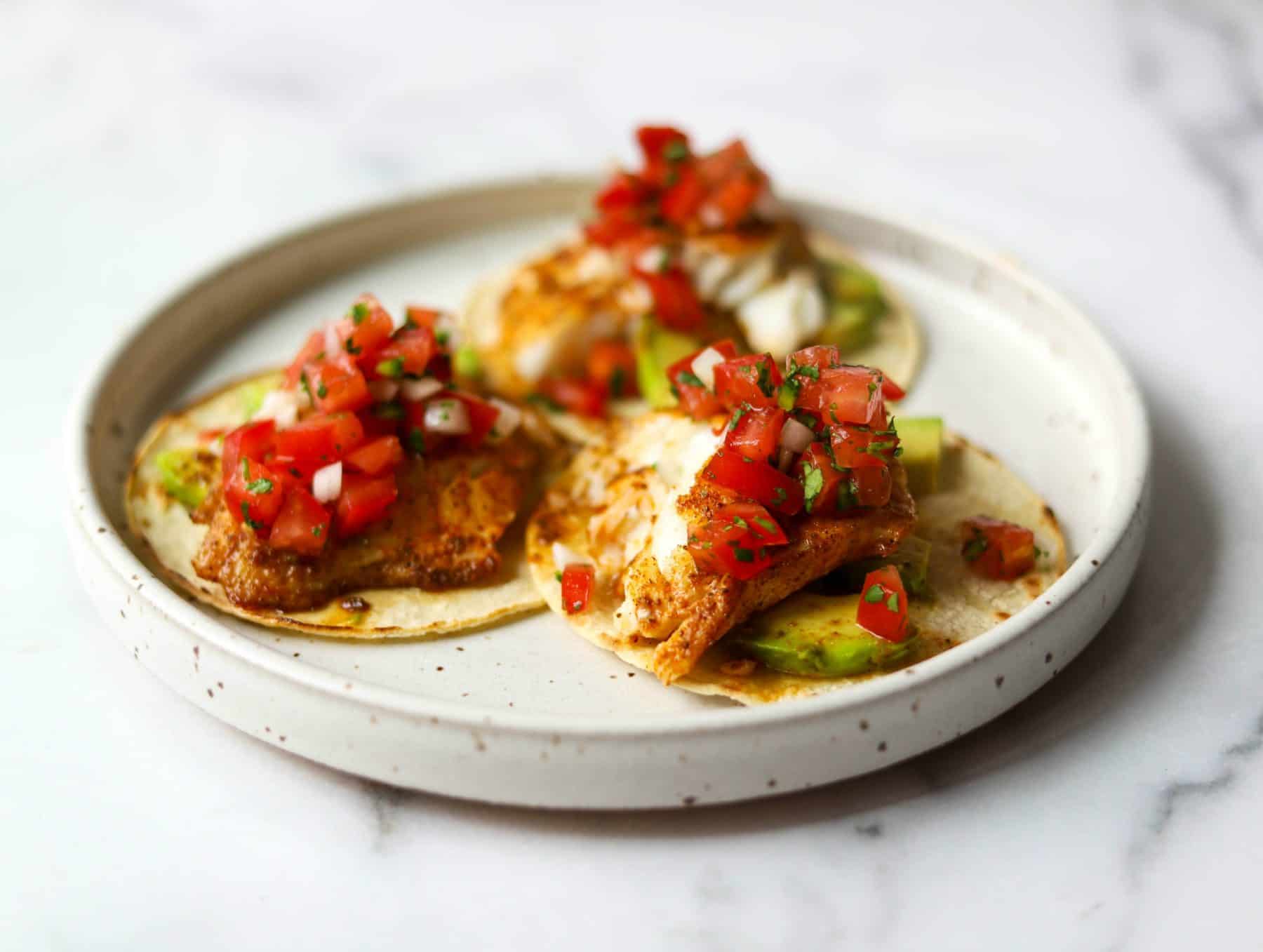 Fish tacos on a white plate