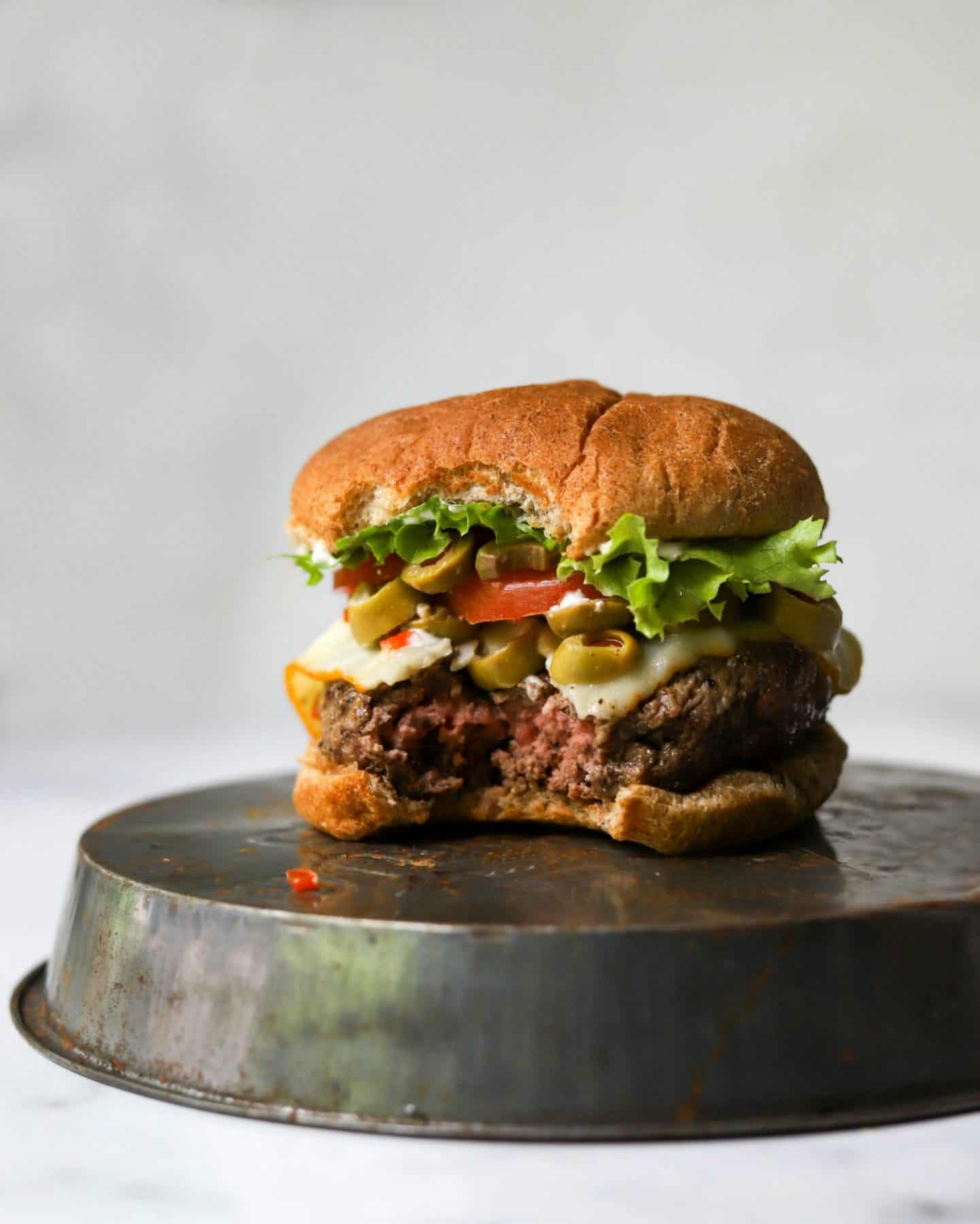 Cheesy olive burgers on a tin