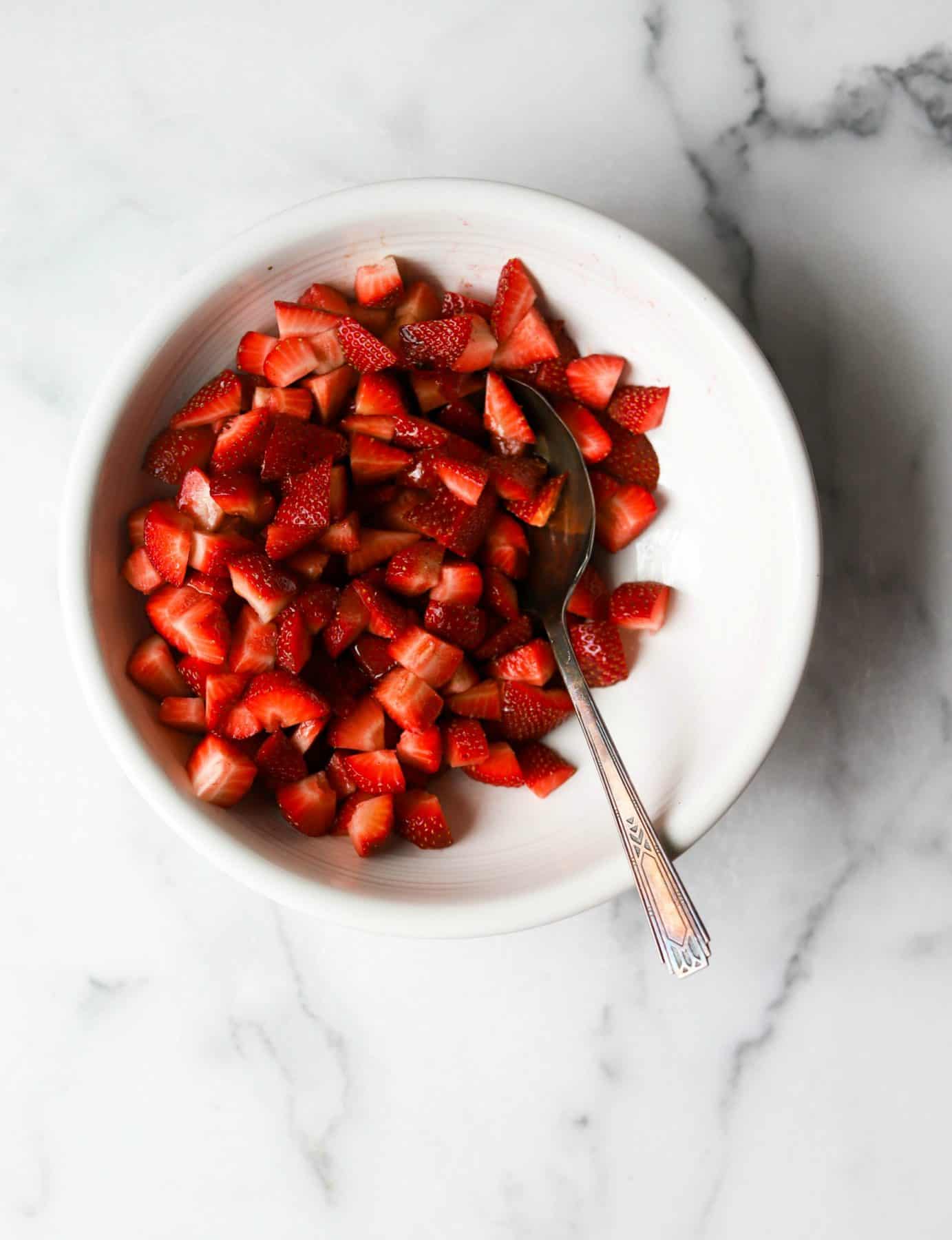 Chopped strawberries in a white bowl