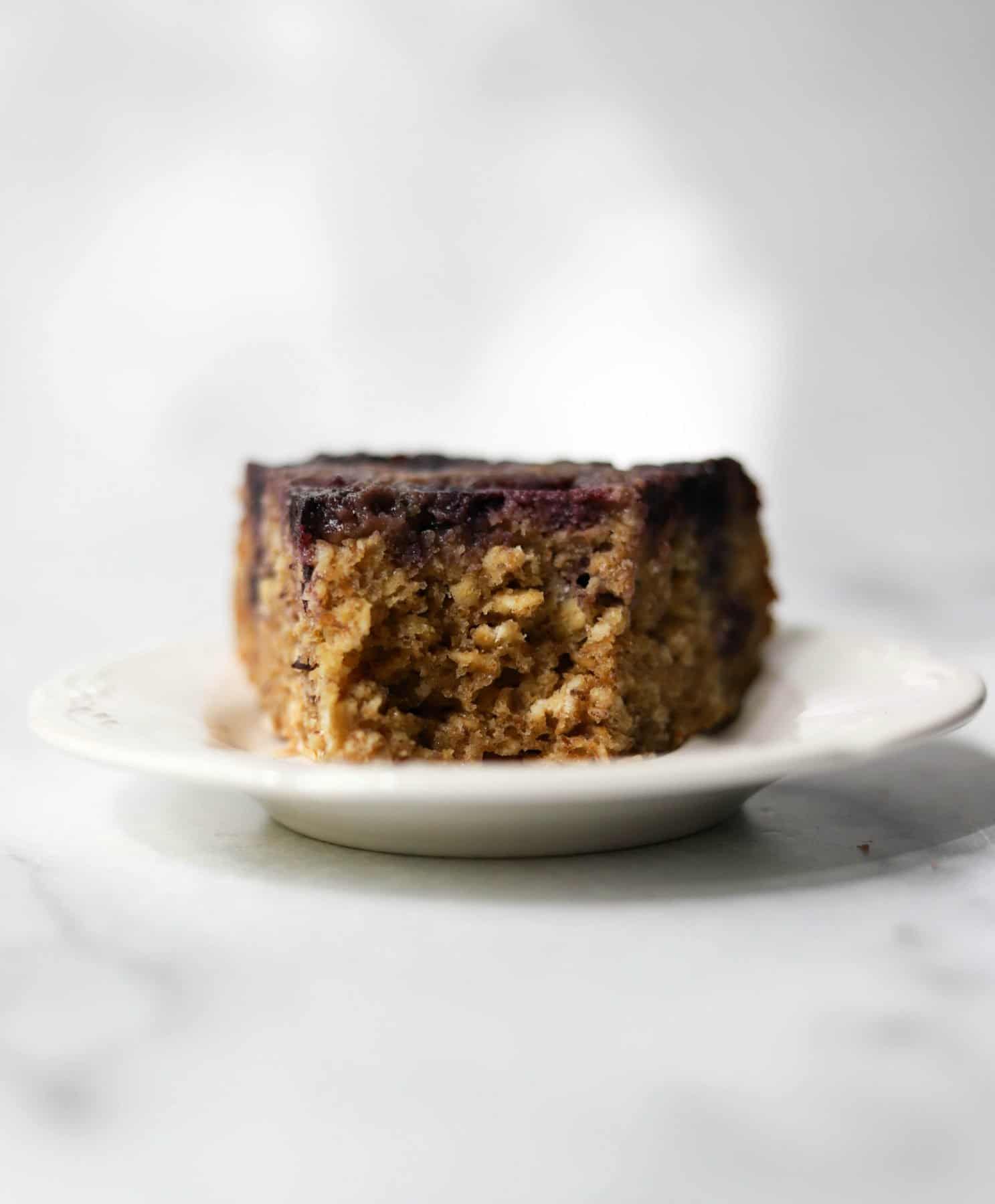 A slice of blueberry cake on a white plate