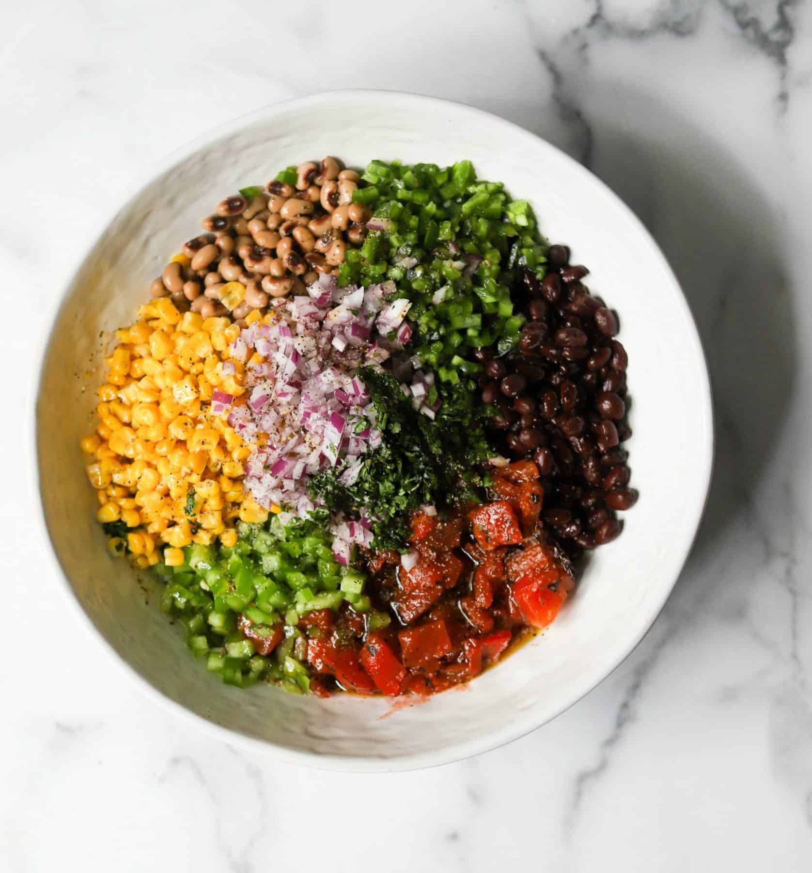 Cowboy caviar ingredients in a white bowl