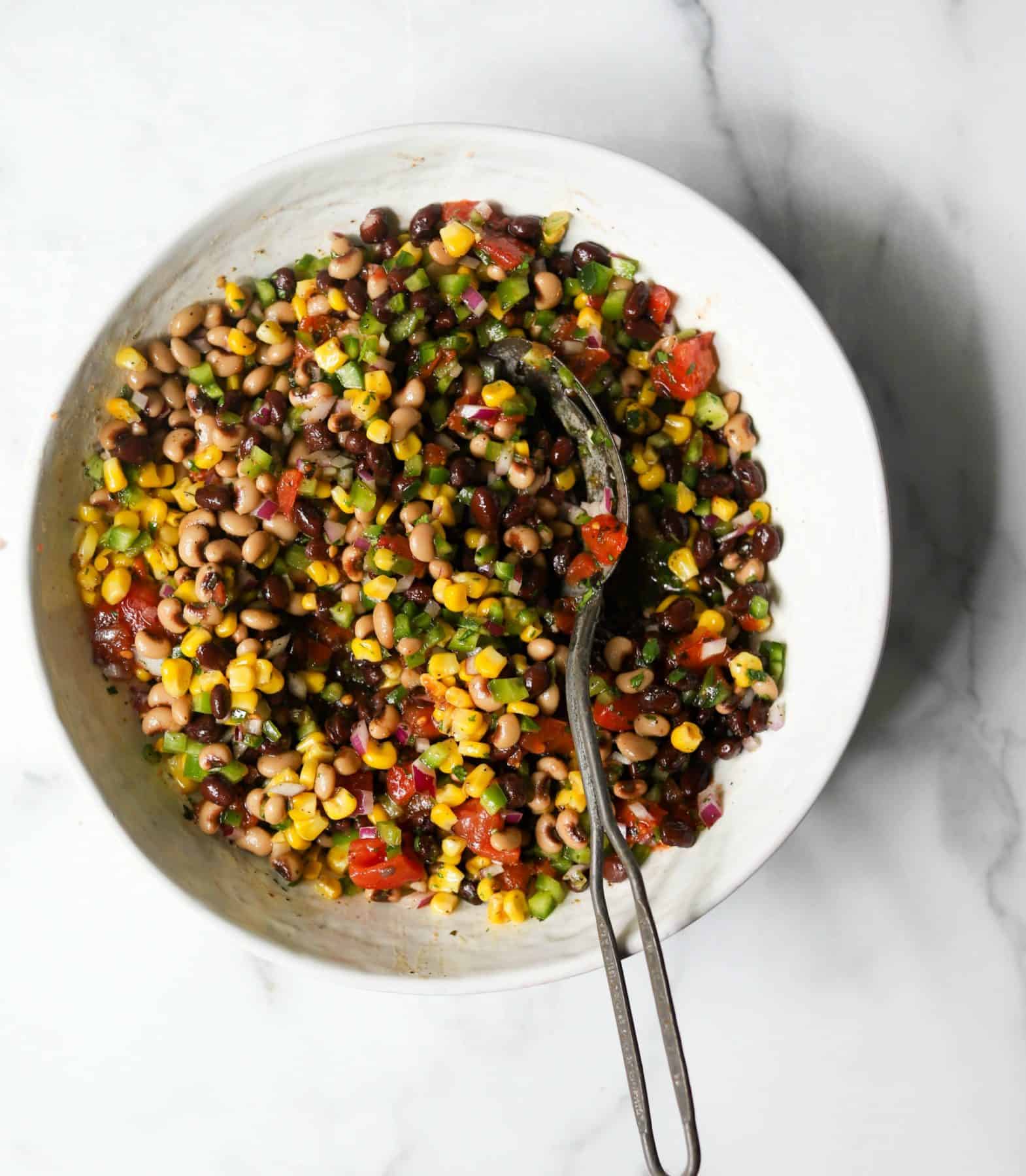 Cowboy caviar in a white bowl with a spoon