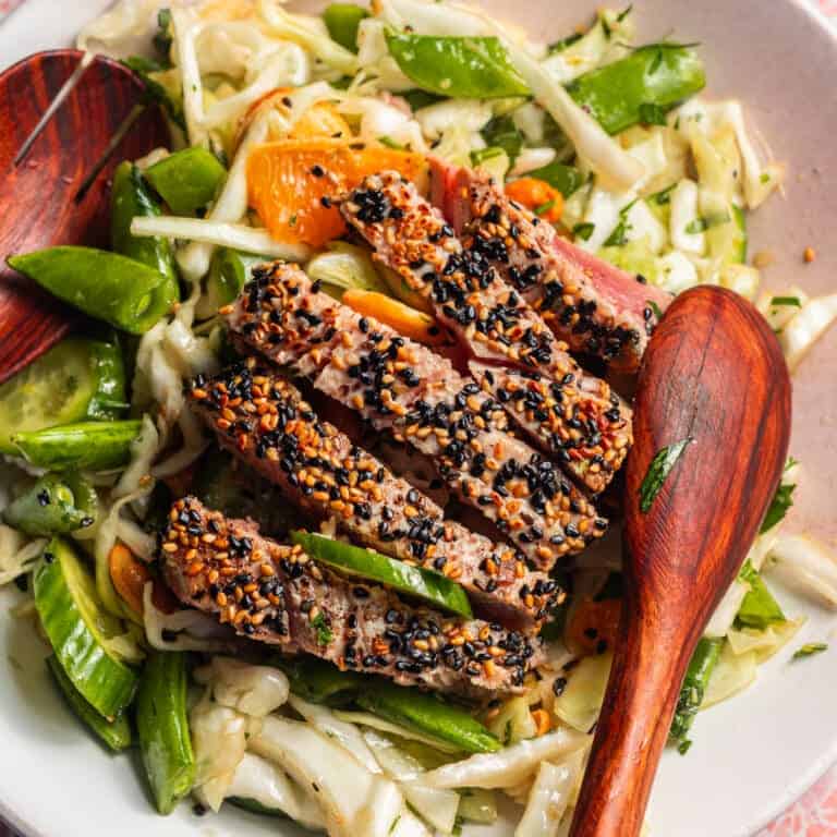 A cabbage, pea and orange salad with seared sesame tuna on top.