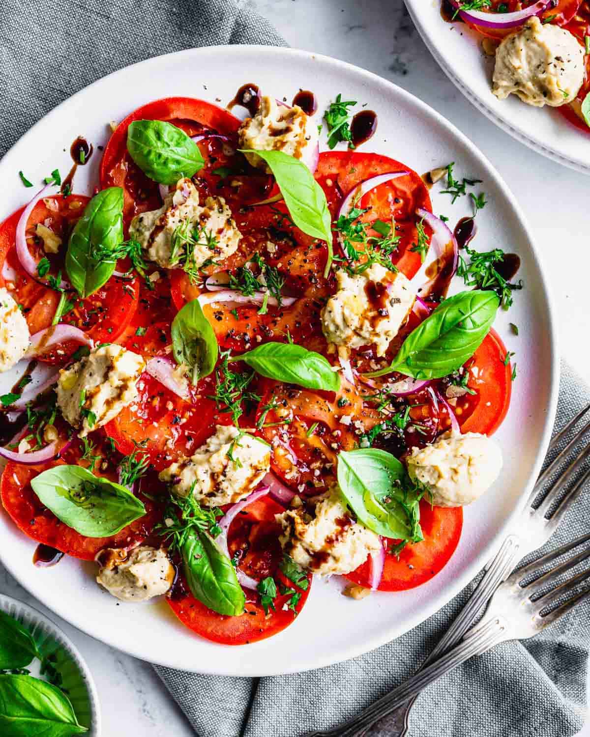 An overhead shot of a platter of tomato carpaccio.