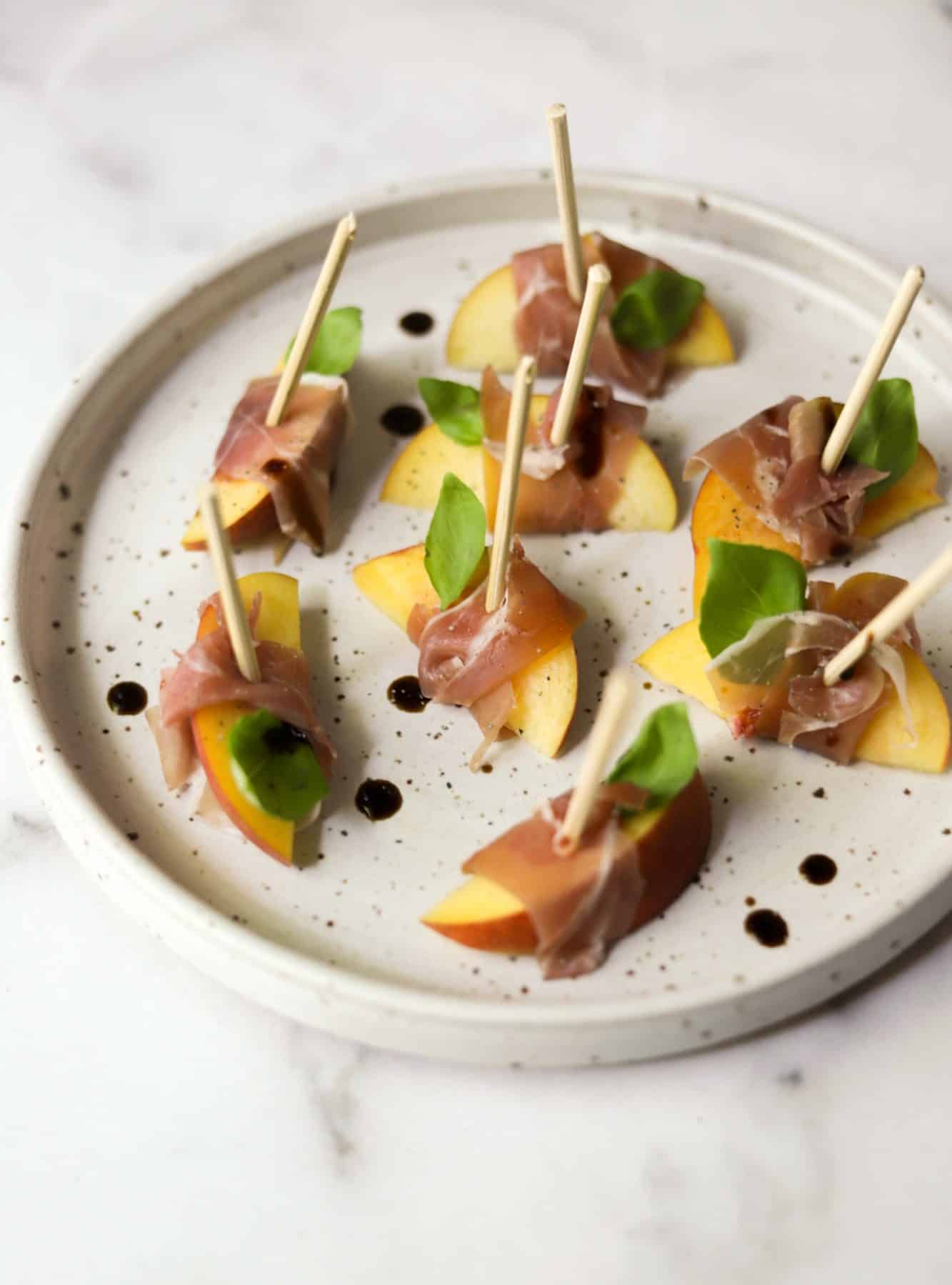 Peach prosciutto bites on a stone plate