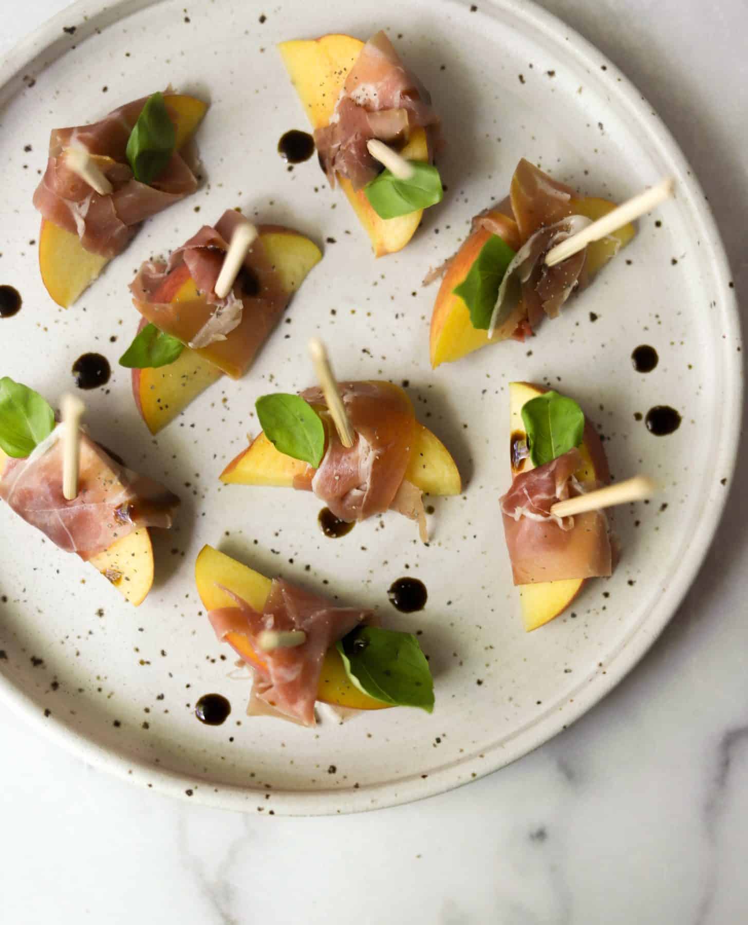 Peach prosciutto bites on a stone plate