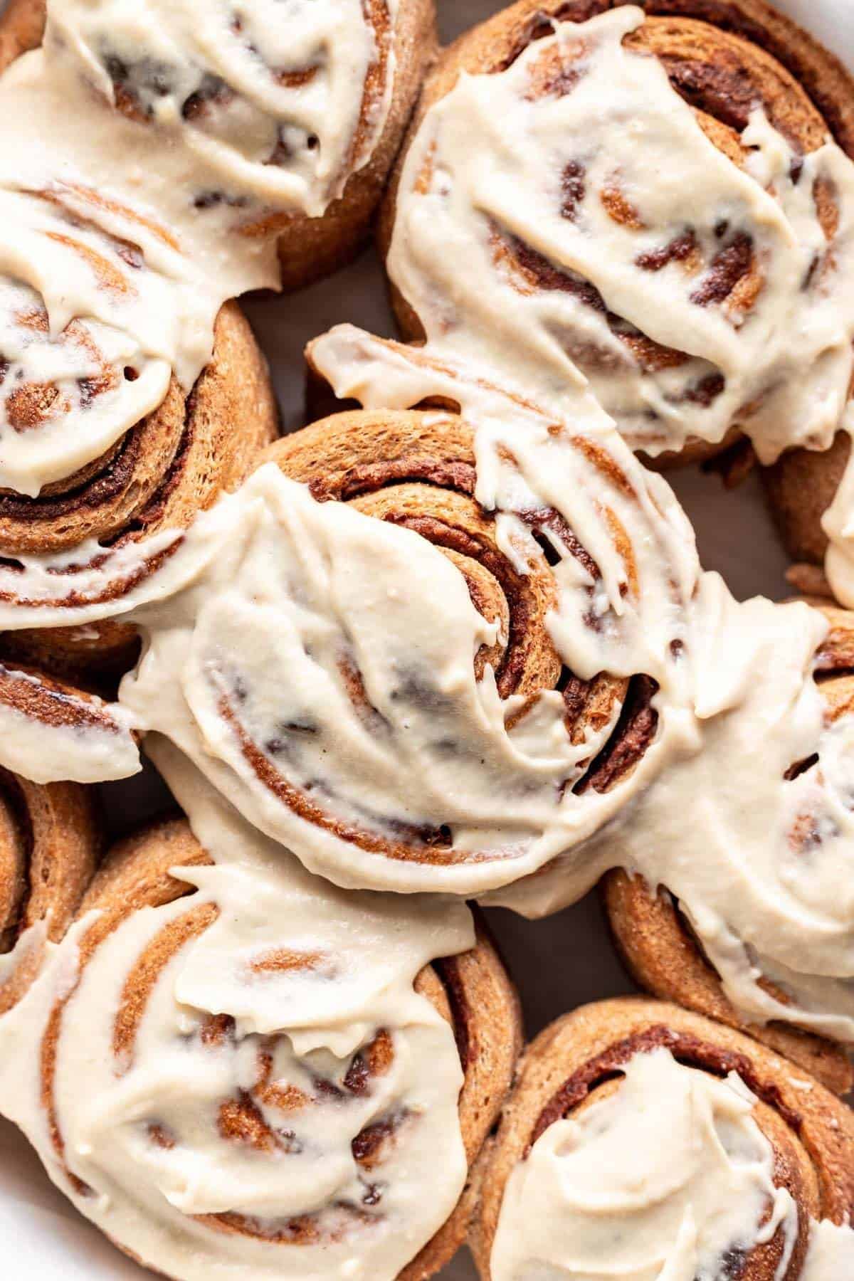 A close up overhead shot of whole wheat cinnamon rolls with icing on top.