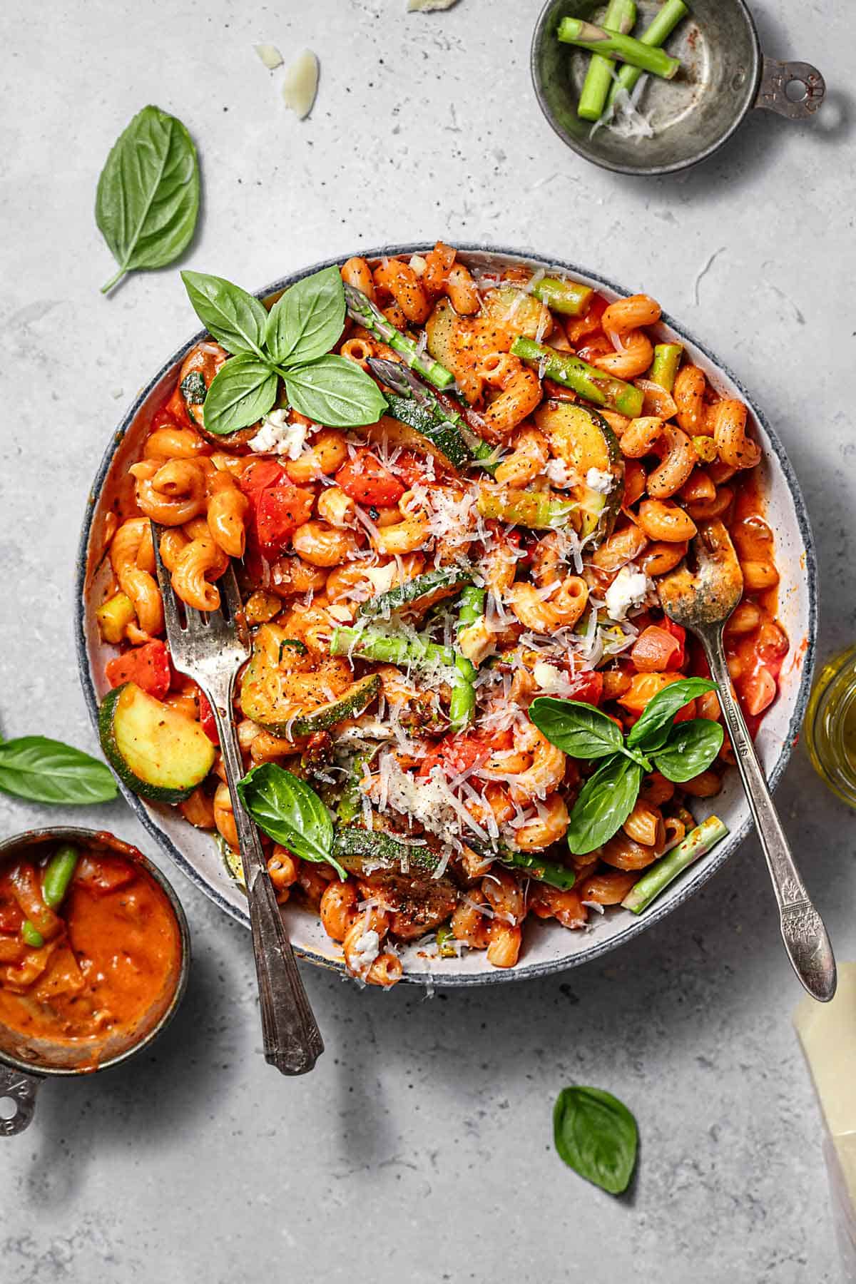 An overhead shot of a bowl of vegetable tomato pasta.