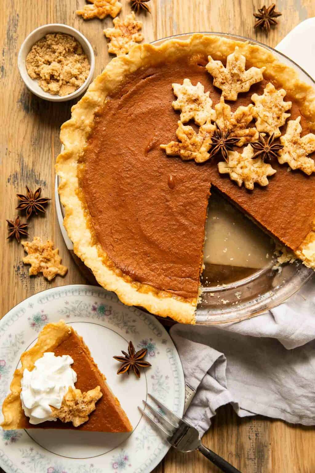 An overhead shot of a dairy free pumpkin pie with a slice missing.