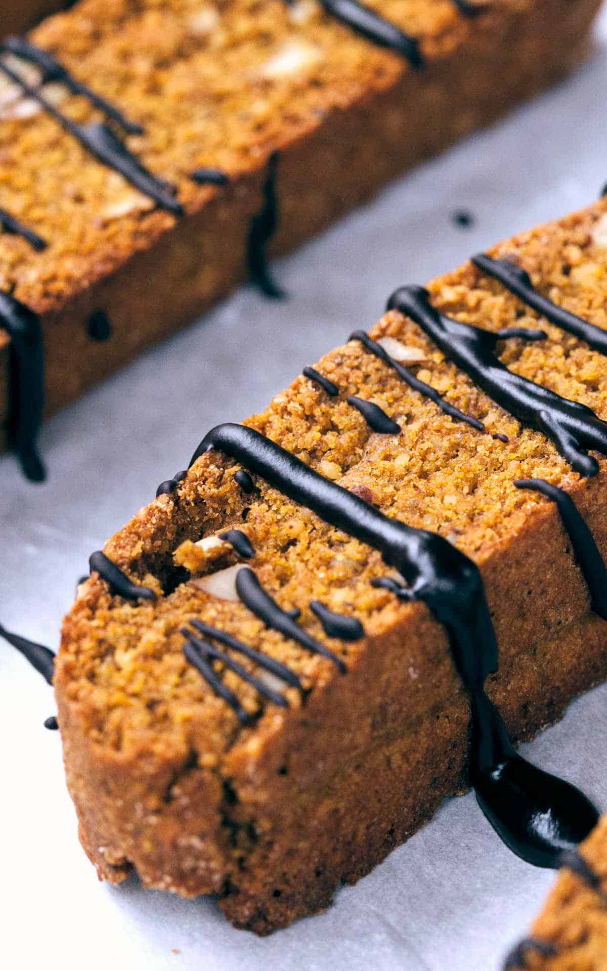 A side shot of a pumpkin biscotti drizzled with chocolate.