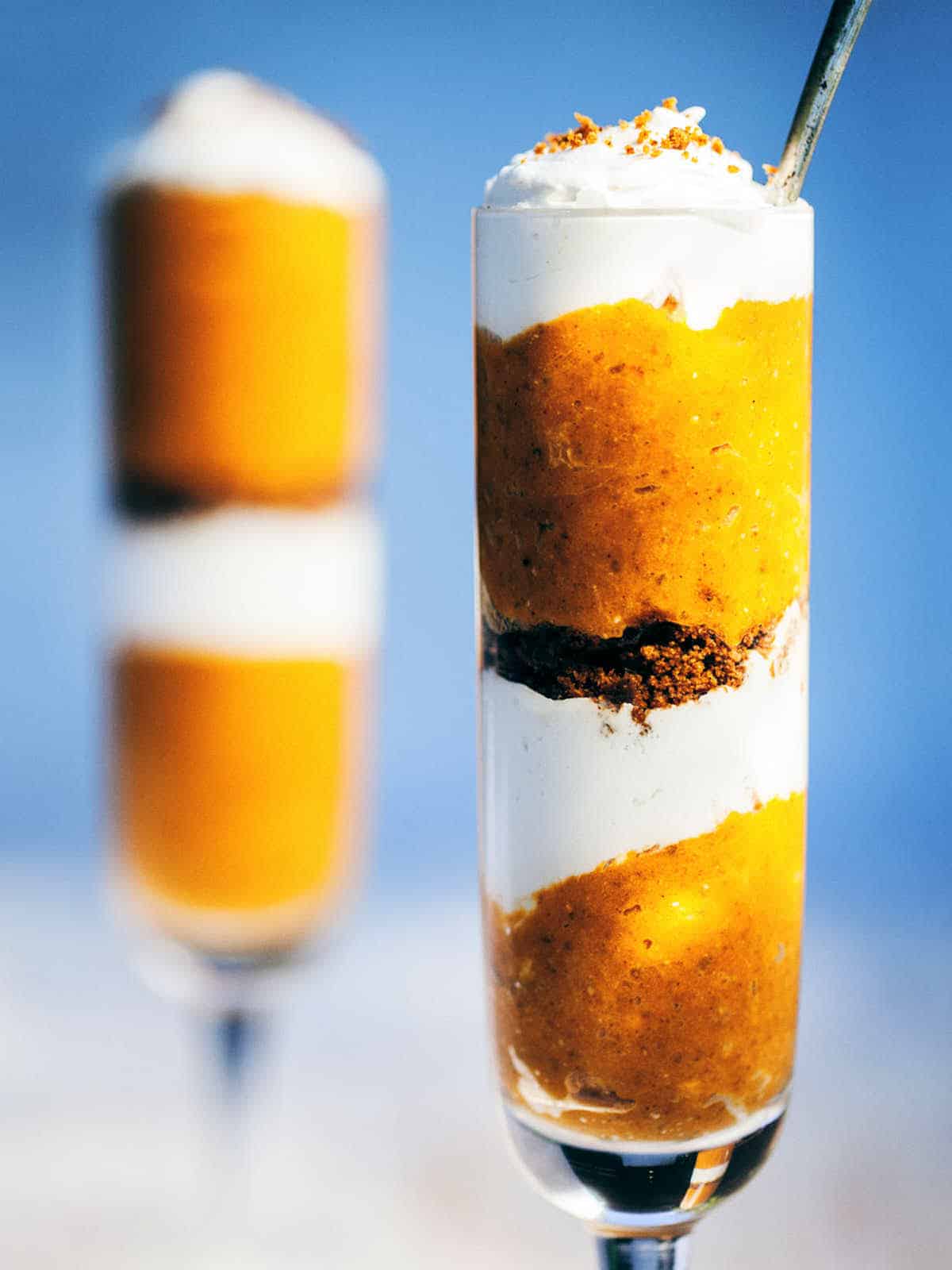 A front shot of skinny glasses of pumpkin pie parfaits.