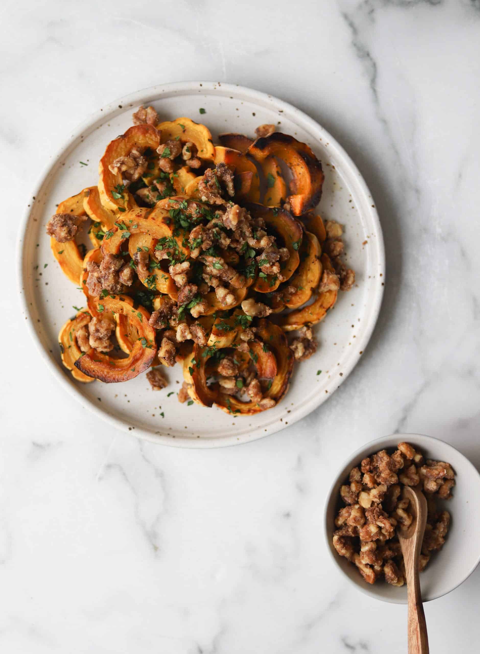 Delicata squash with walnut crumble on a white plate