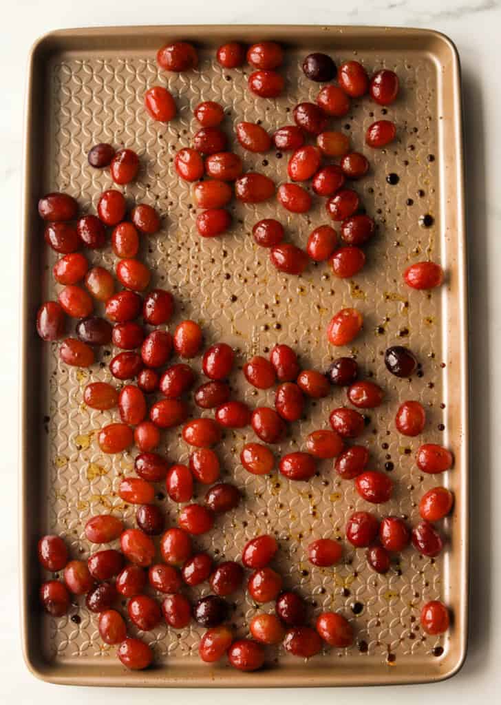 An overhead shot of a baking sheet with grapes on it.