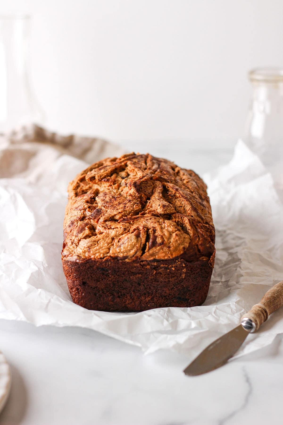 A front shot of a loaf of peanut butter swirled banana bread.
