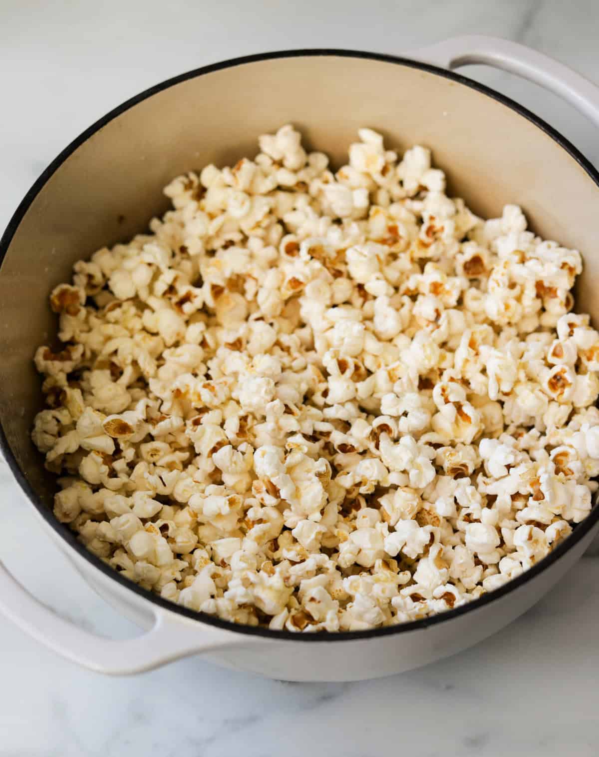A front angled shot of a pot of stovetop popcorn.