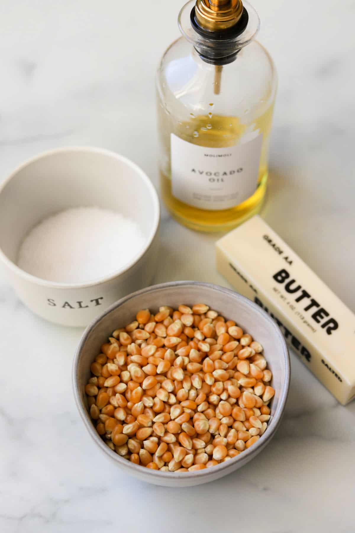 Popcorn ingredients on a marble backdrop.