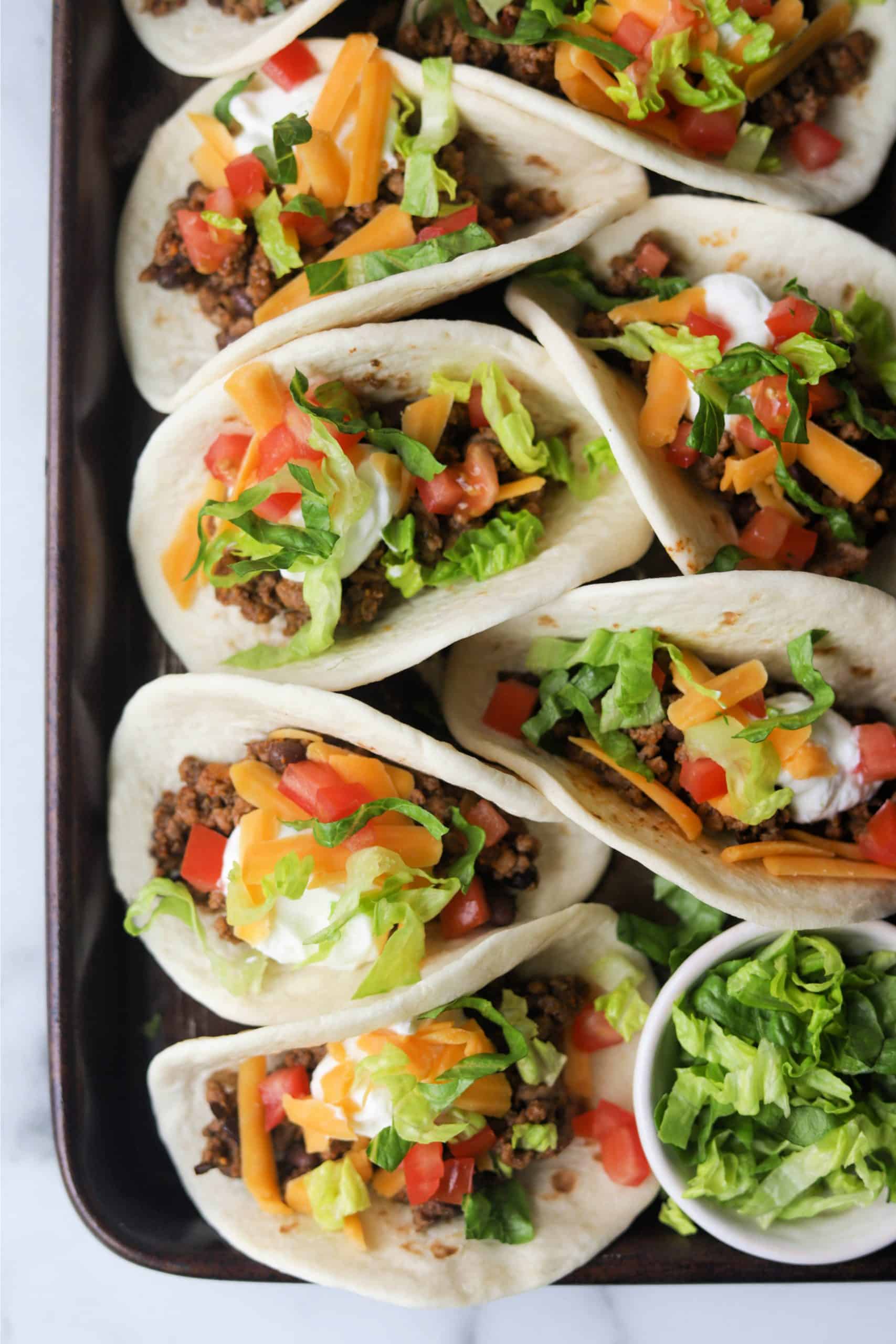 A sheet tray filled with classic beef tacos.
