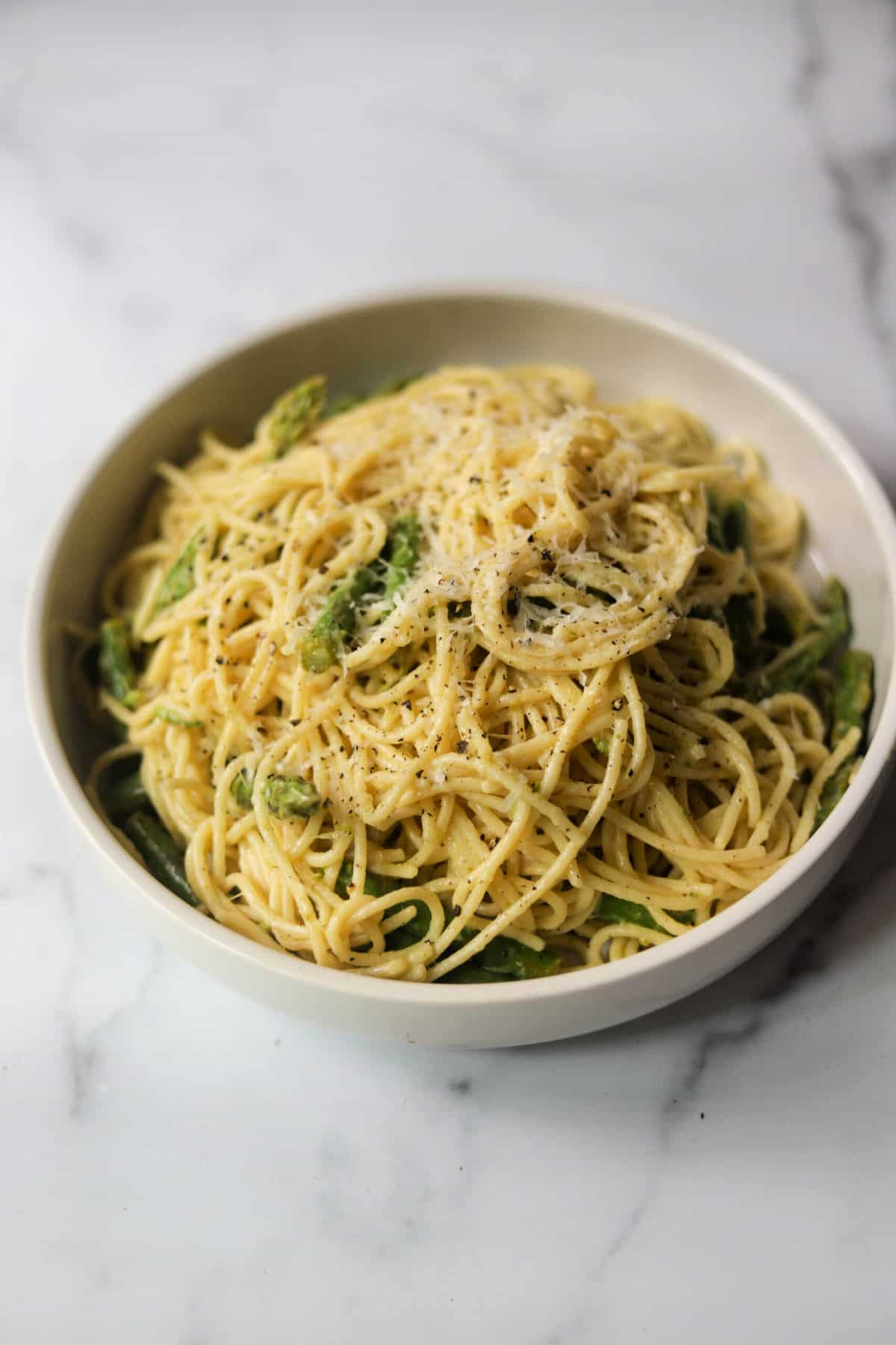 A white bowl filled with lemon asparagus pasta.