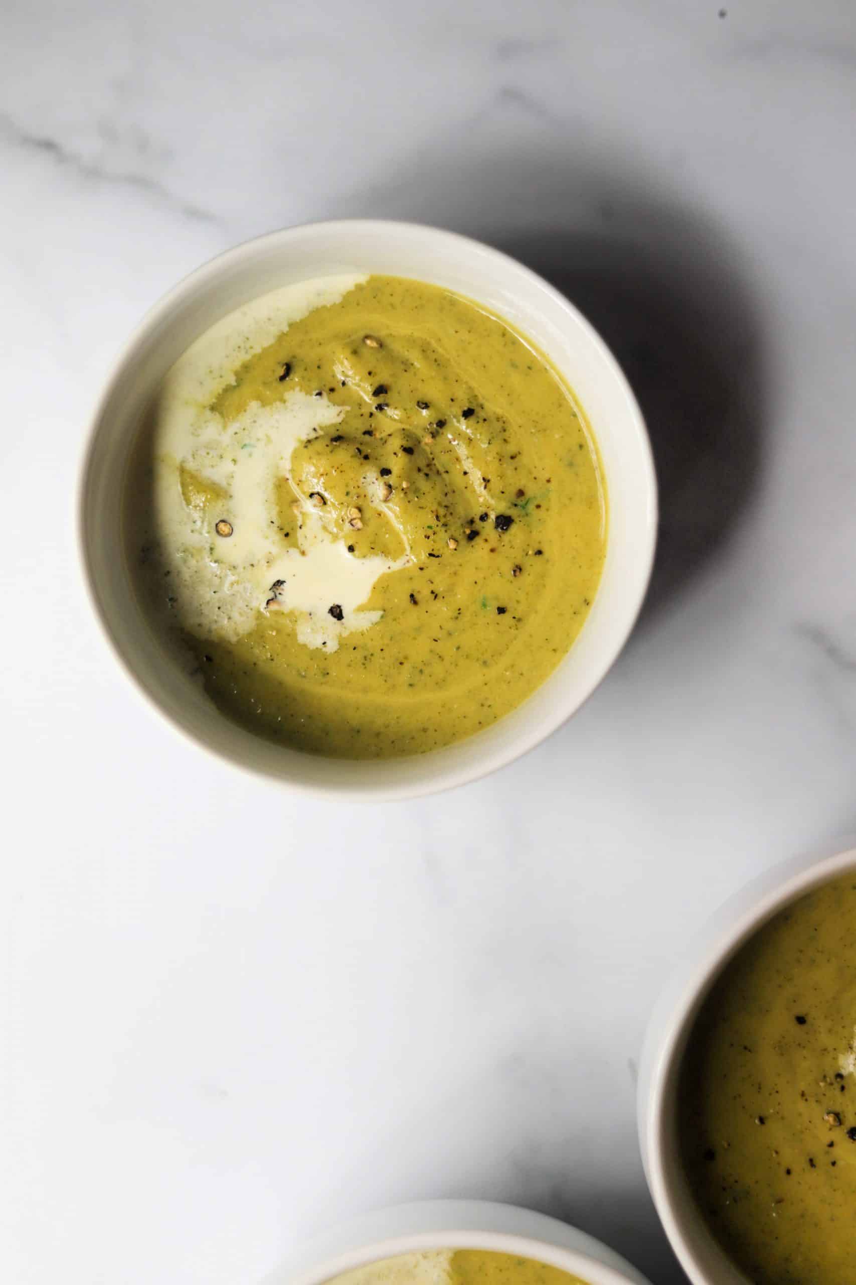White bowls filled with spicy zucchini soup.