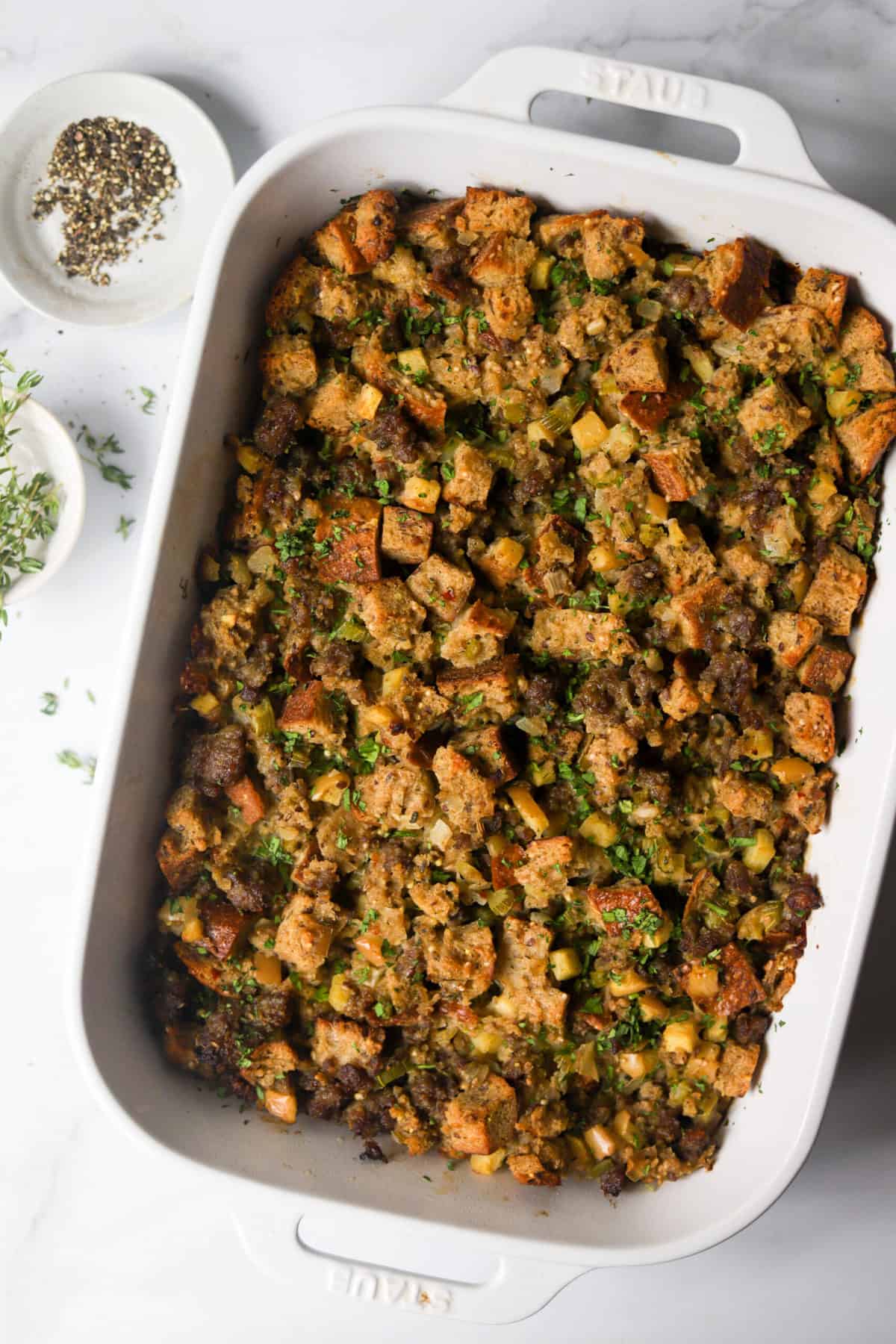 An overhead shot of a baking dish filled with apple sausage stuffing.