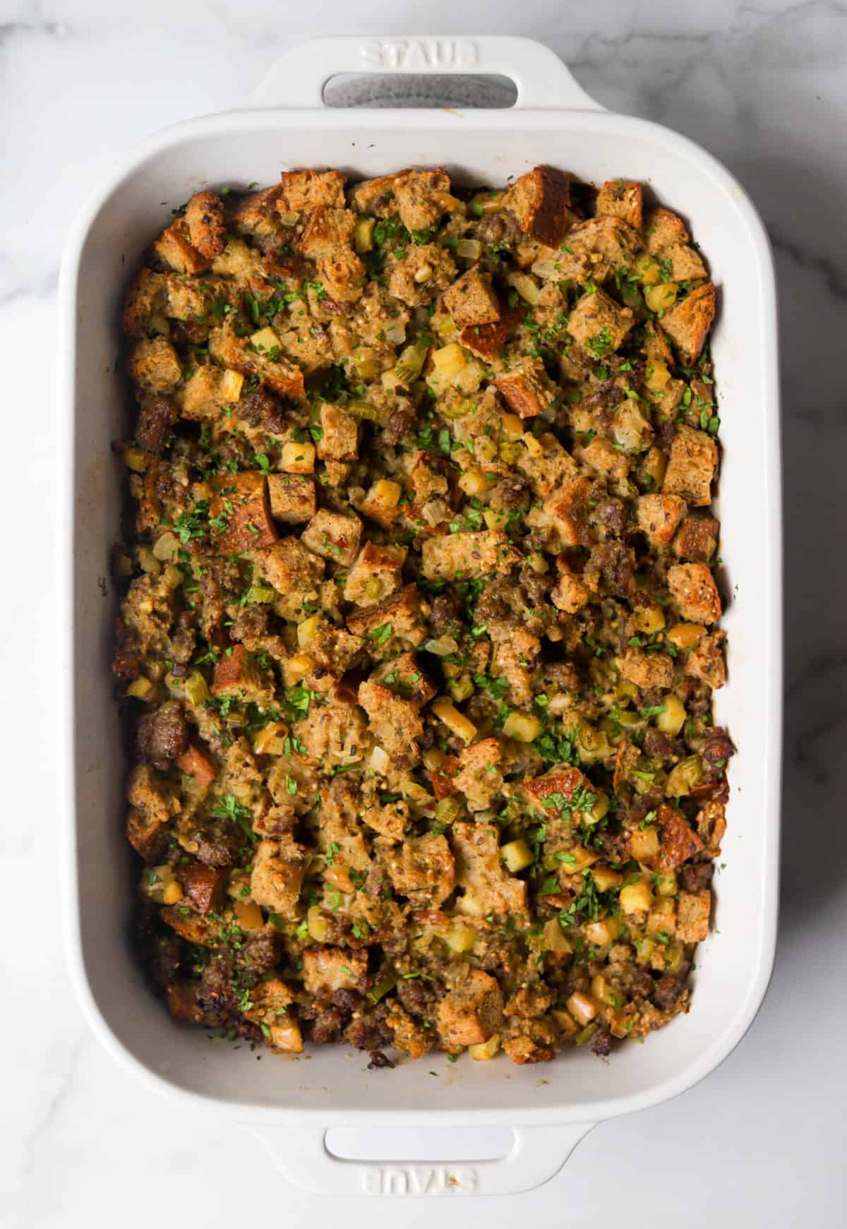 An overhead shot of a baking dish filled with apple sausage stuffing.