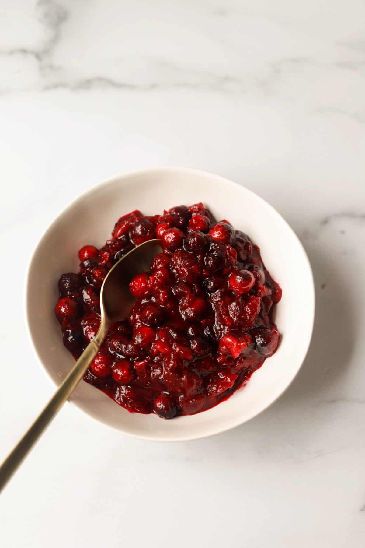 A side shot of a bowl of cranberry sauce.