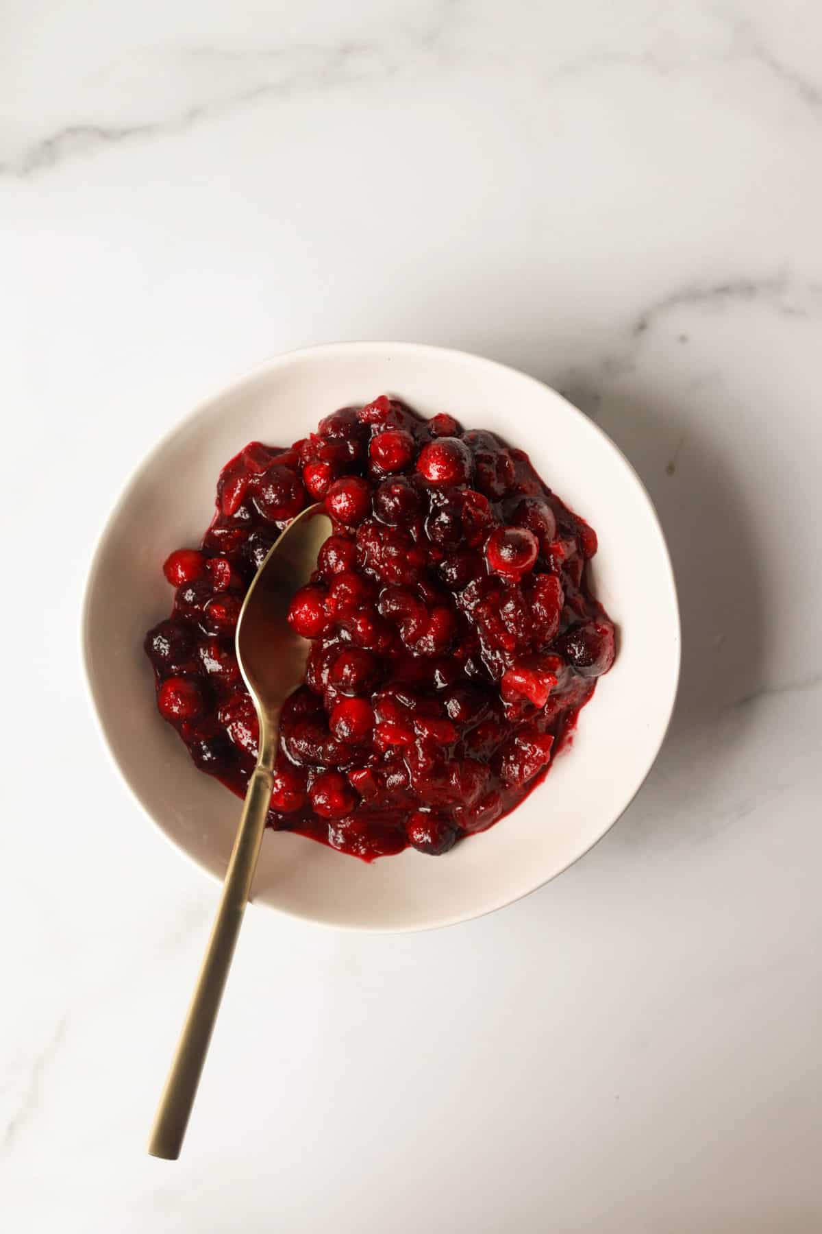 A overhead shot of a bowl of cranberry sauce.