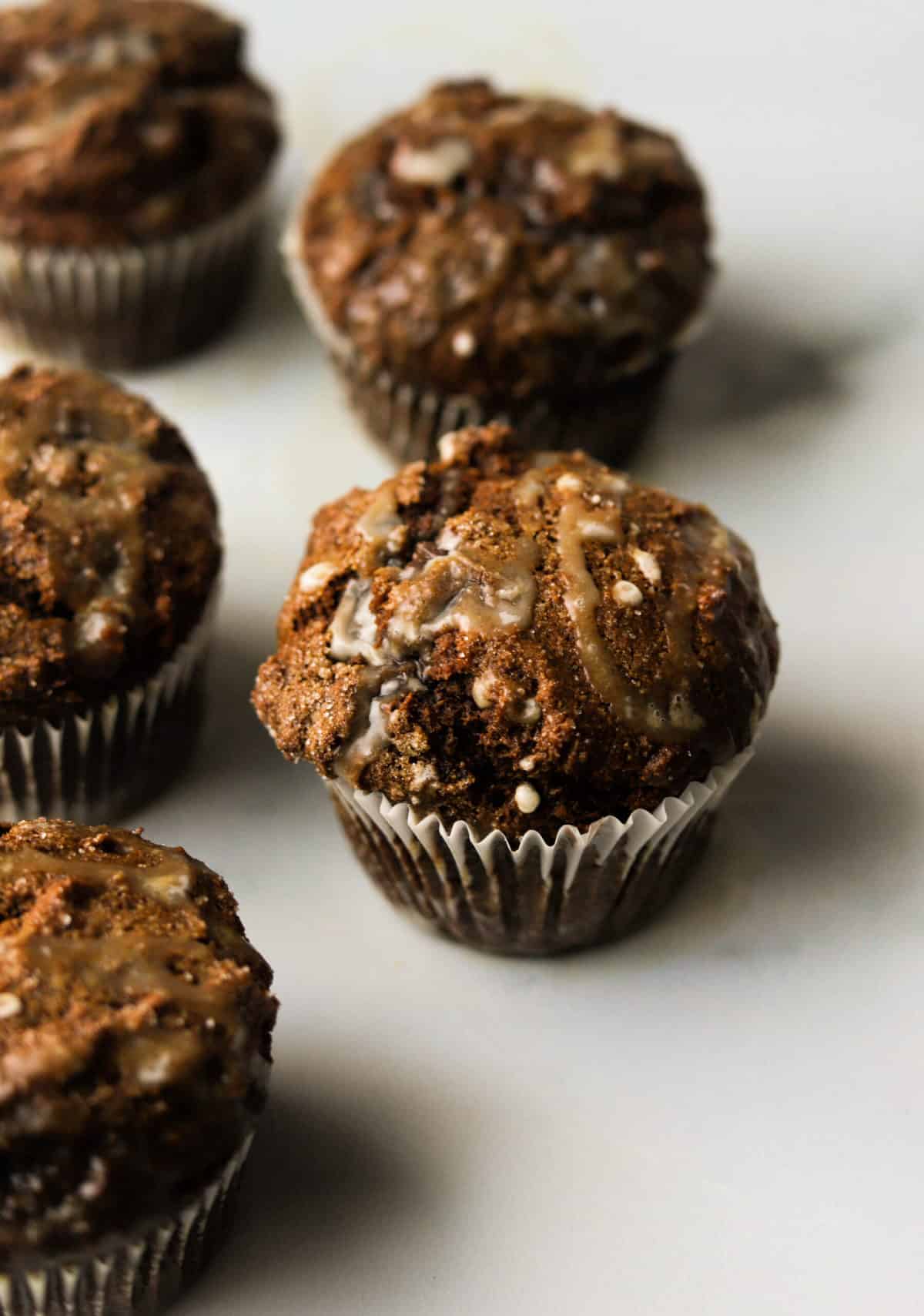 A side shot of healthy gingerbread muffins on a marble backdrop.