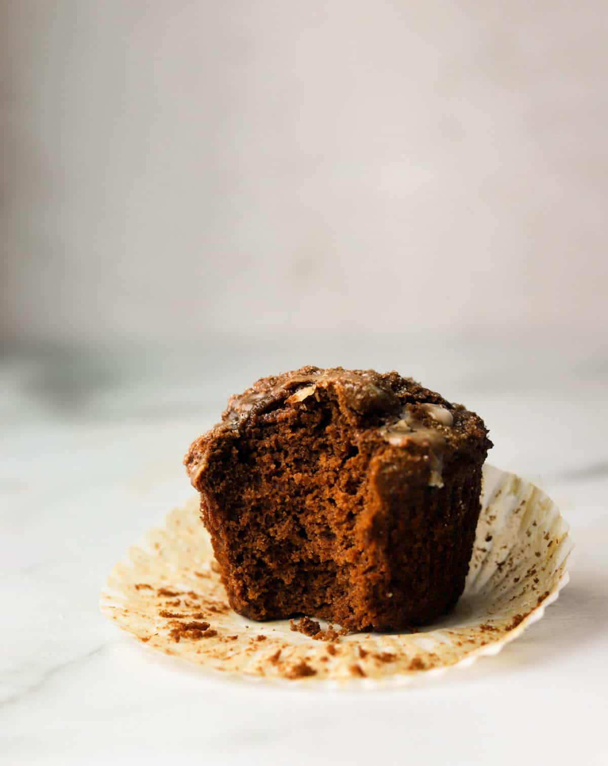 A side shot of a gingerbread muffin with a bite missing.