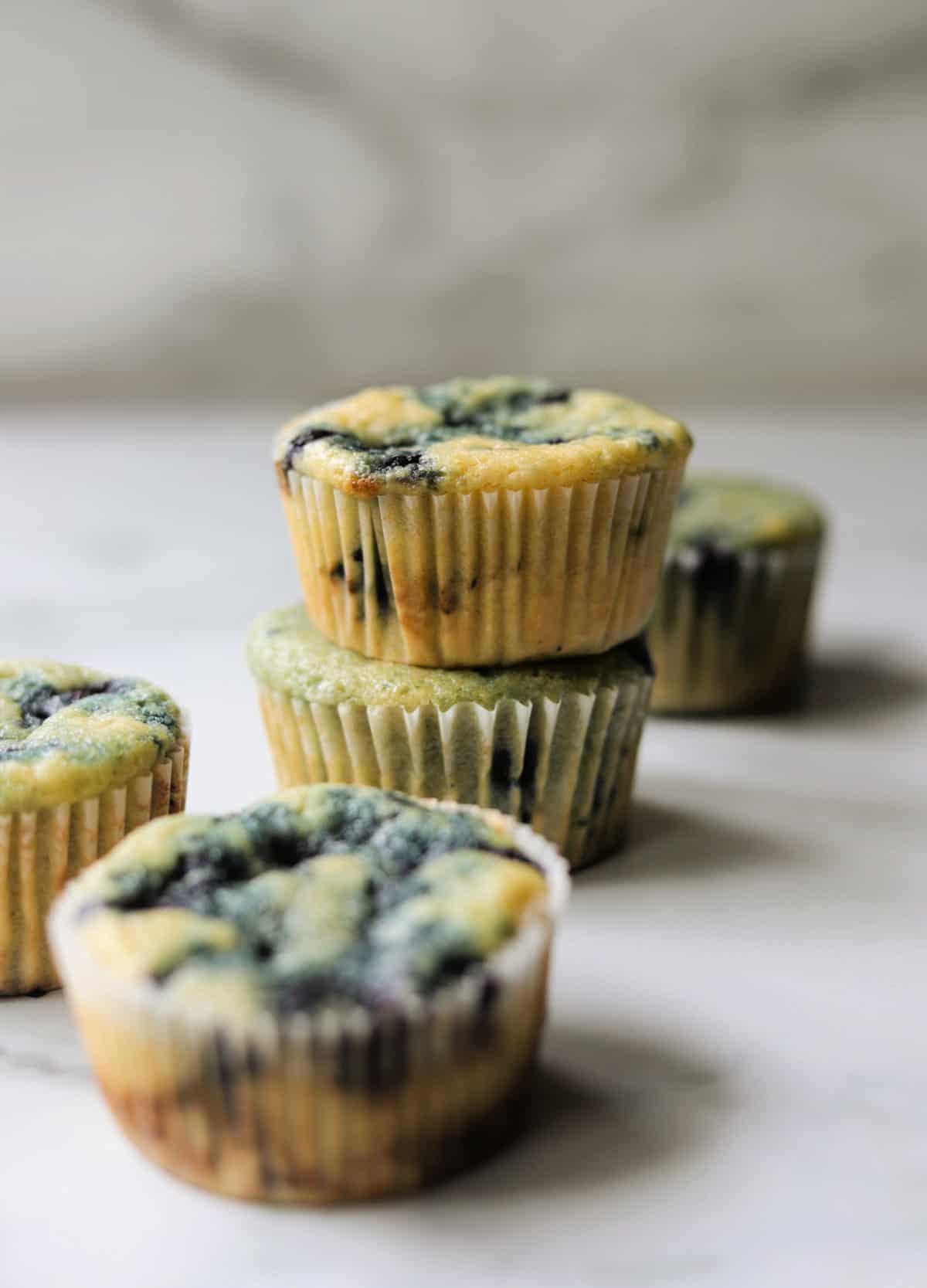 A front shot of a stack of blueberry muffins.
