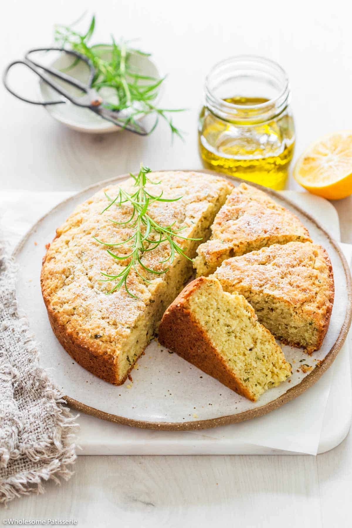 A side shot of a plate of rosemary olive oil cake.