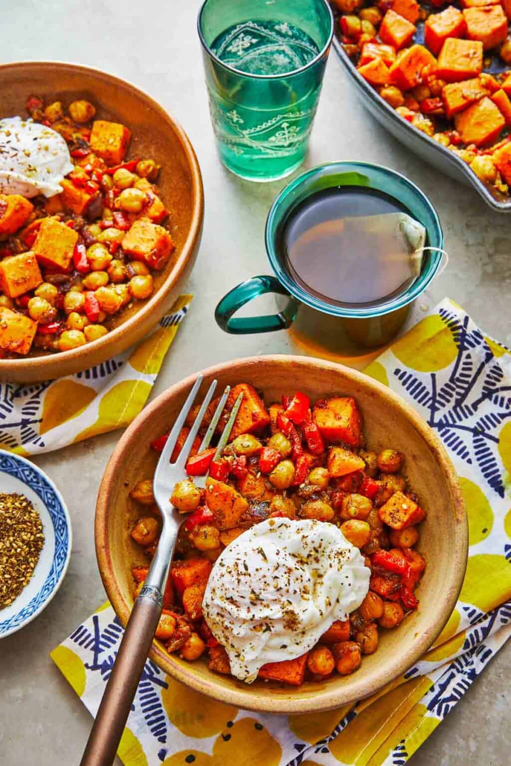 An overhead shot of a  breakfast table with bowls of sweet potato hash.