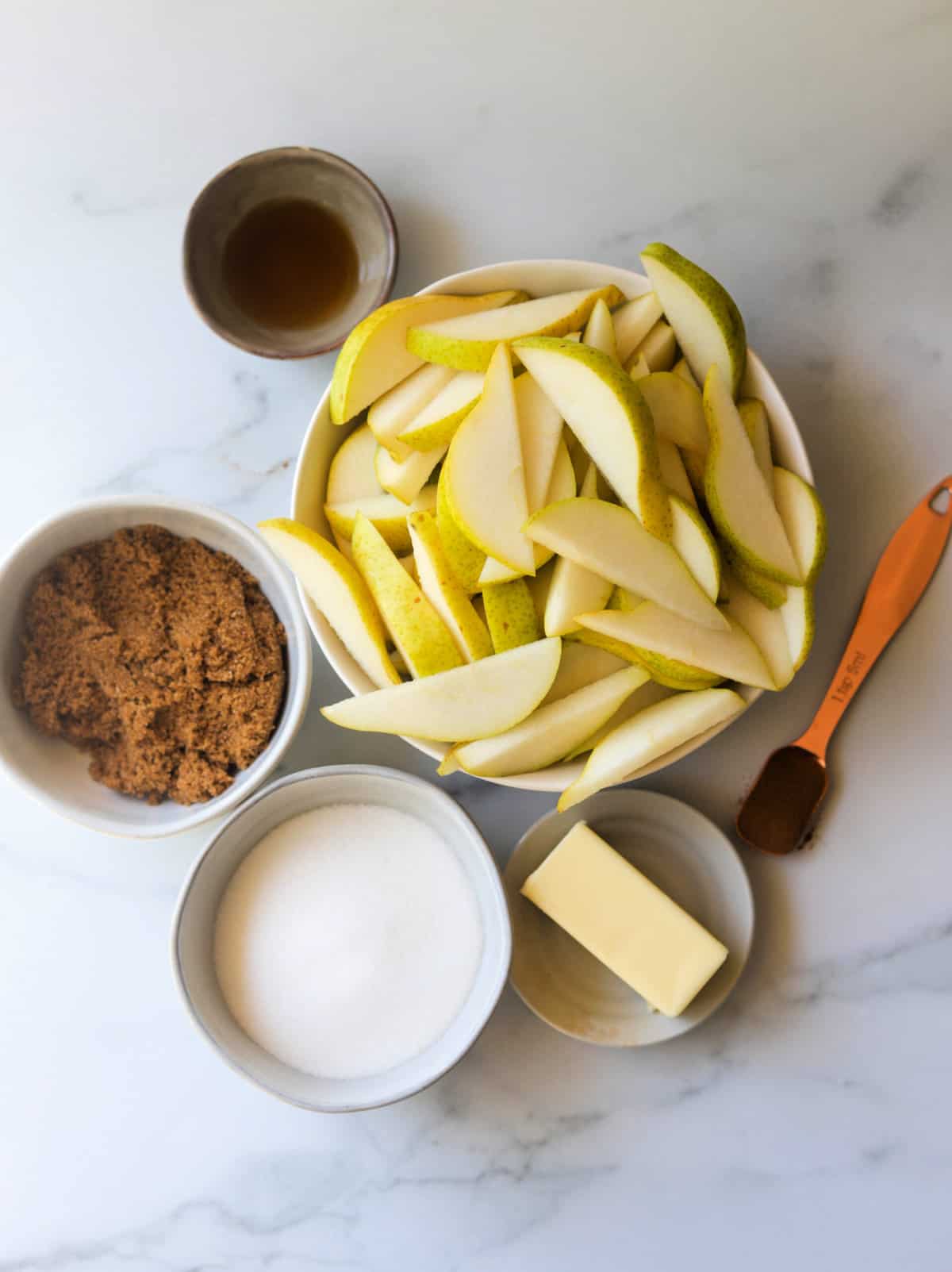 An overhead shot of bowls of ingredients to make pear cobbler.