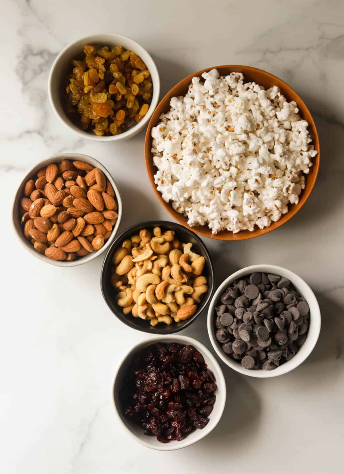 An overhead shot of small bowls of traill mix ingredients.