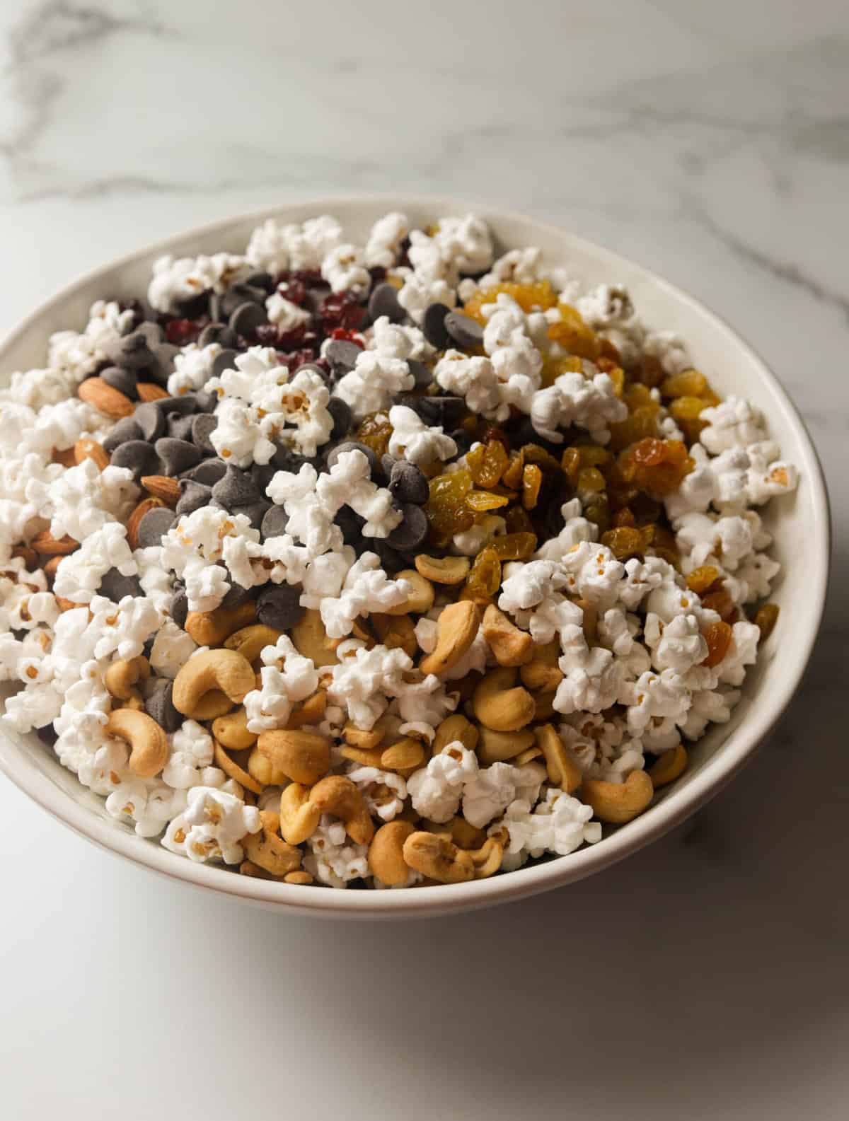 A side shot of a bowl filled with popcorn trail mix.
