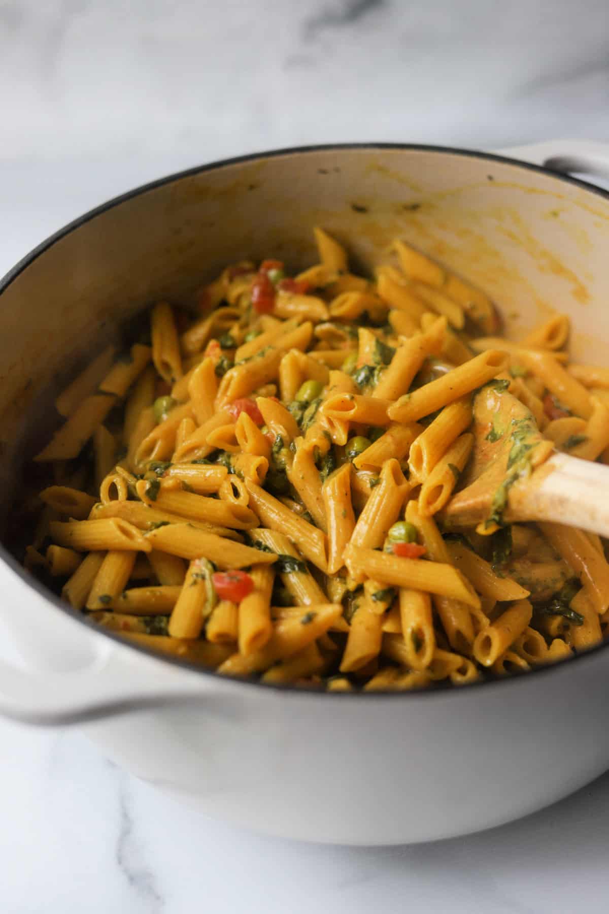 A side close up shot of a pot of curry pasta.