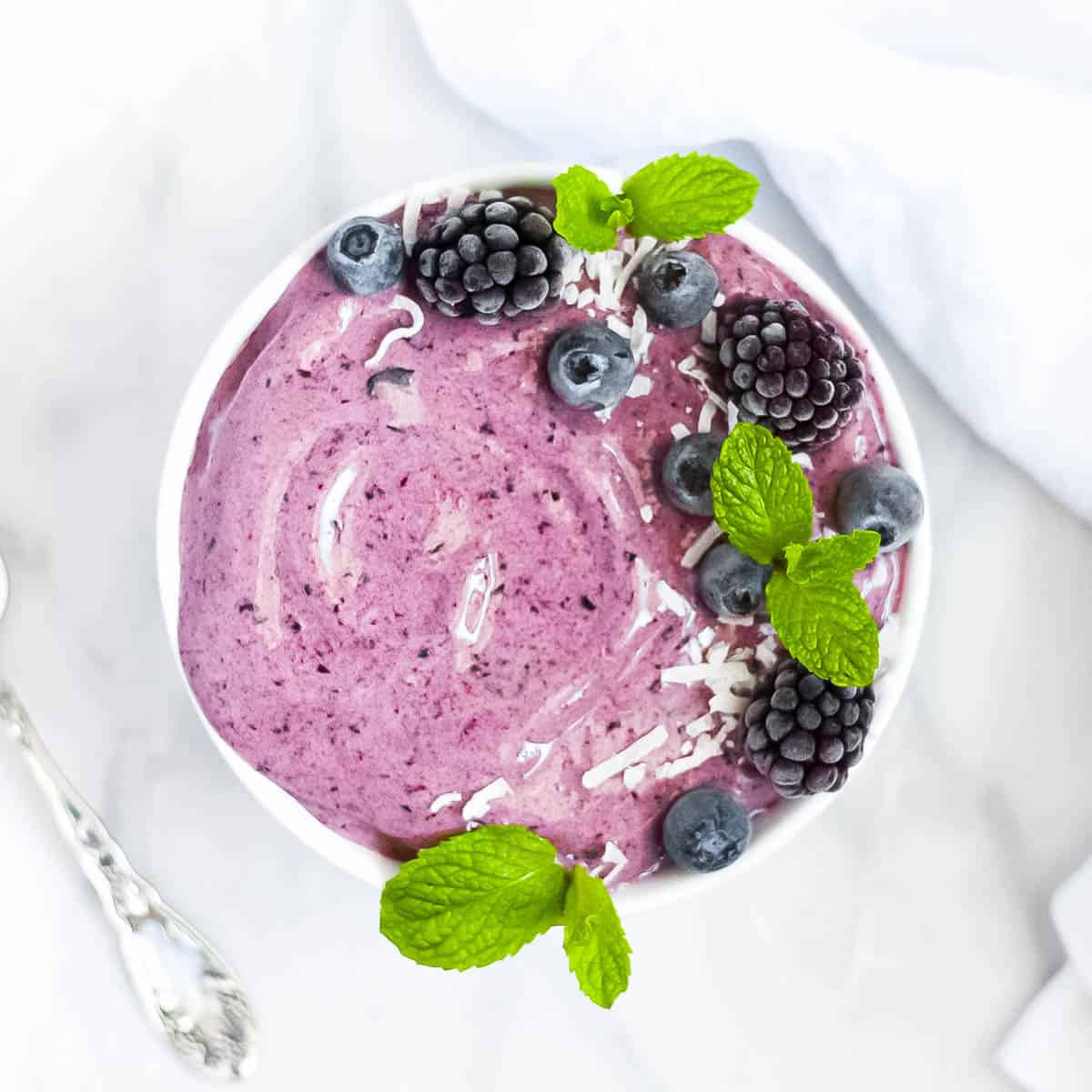 An overhead shot of a blueberry spinach smoothie bowl.