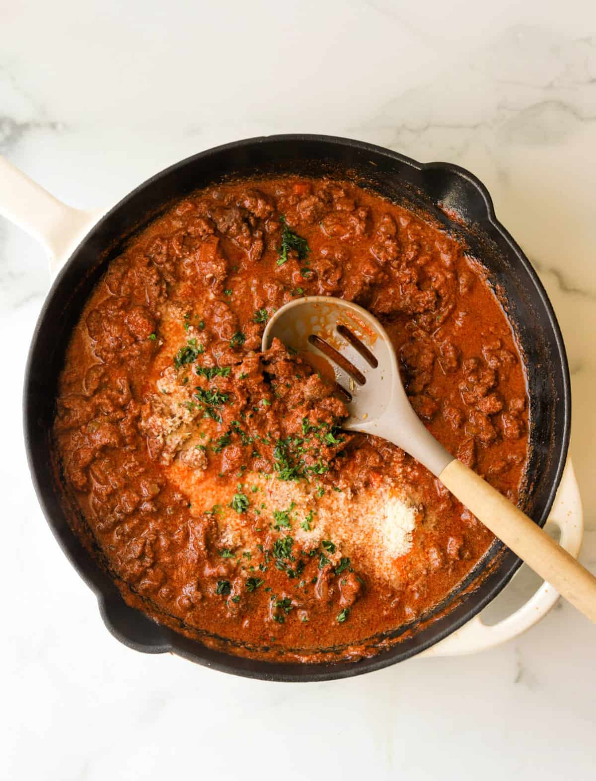 An overhead shot of a skillet filled with bolognese.