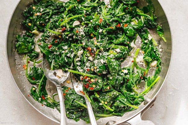 An overhead shot of a pan of sauteed spinach.