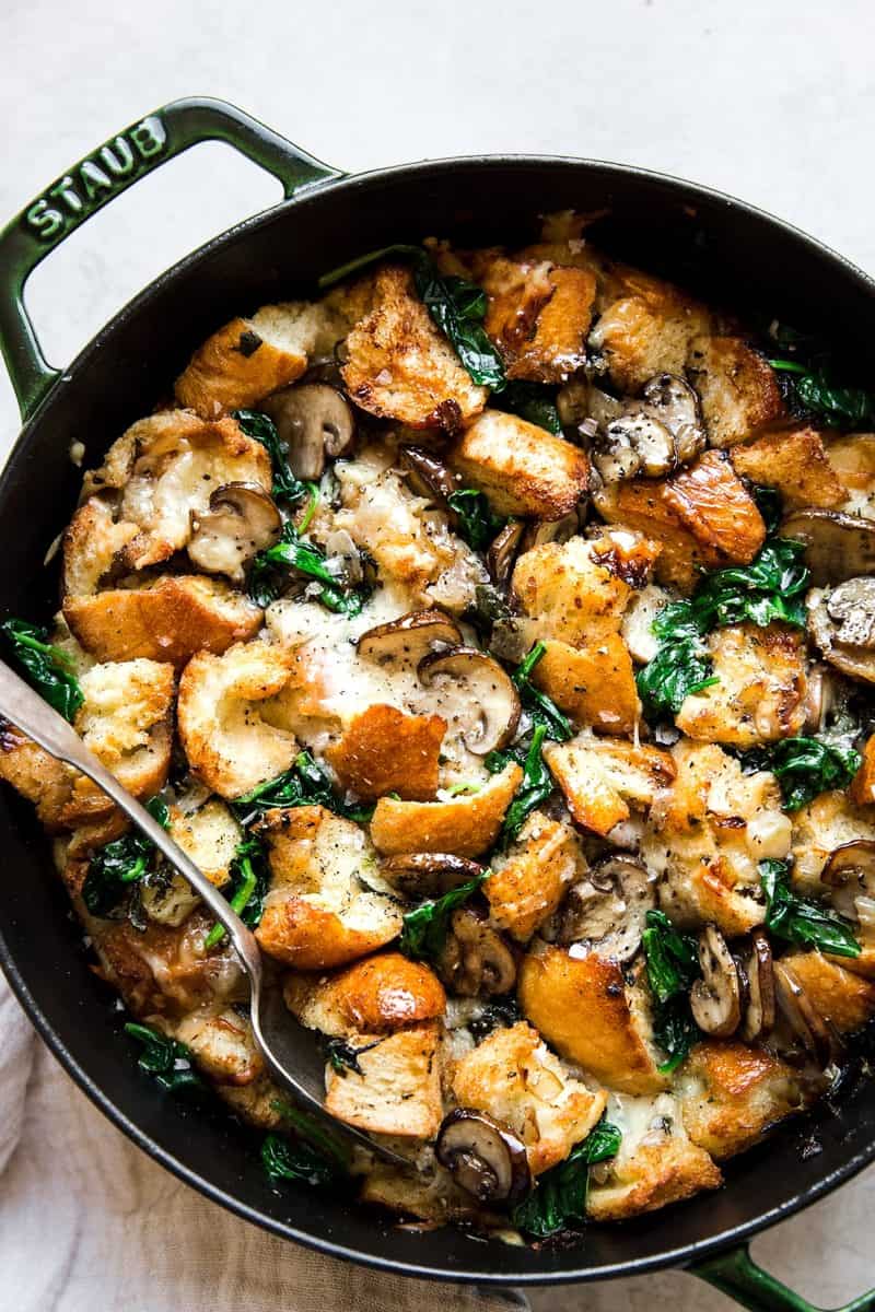 An overhead shot of a spinach mushroom strata in a cast iron pan.