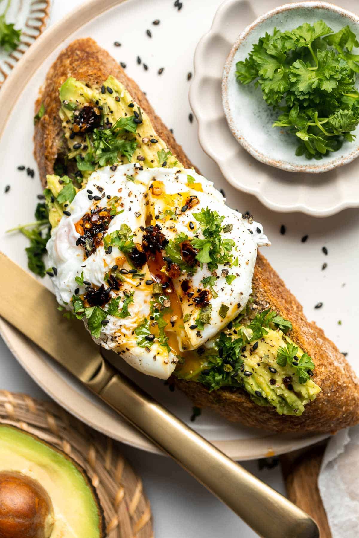 An overhead shot of toast with avocado and egg on top.