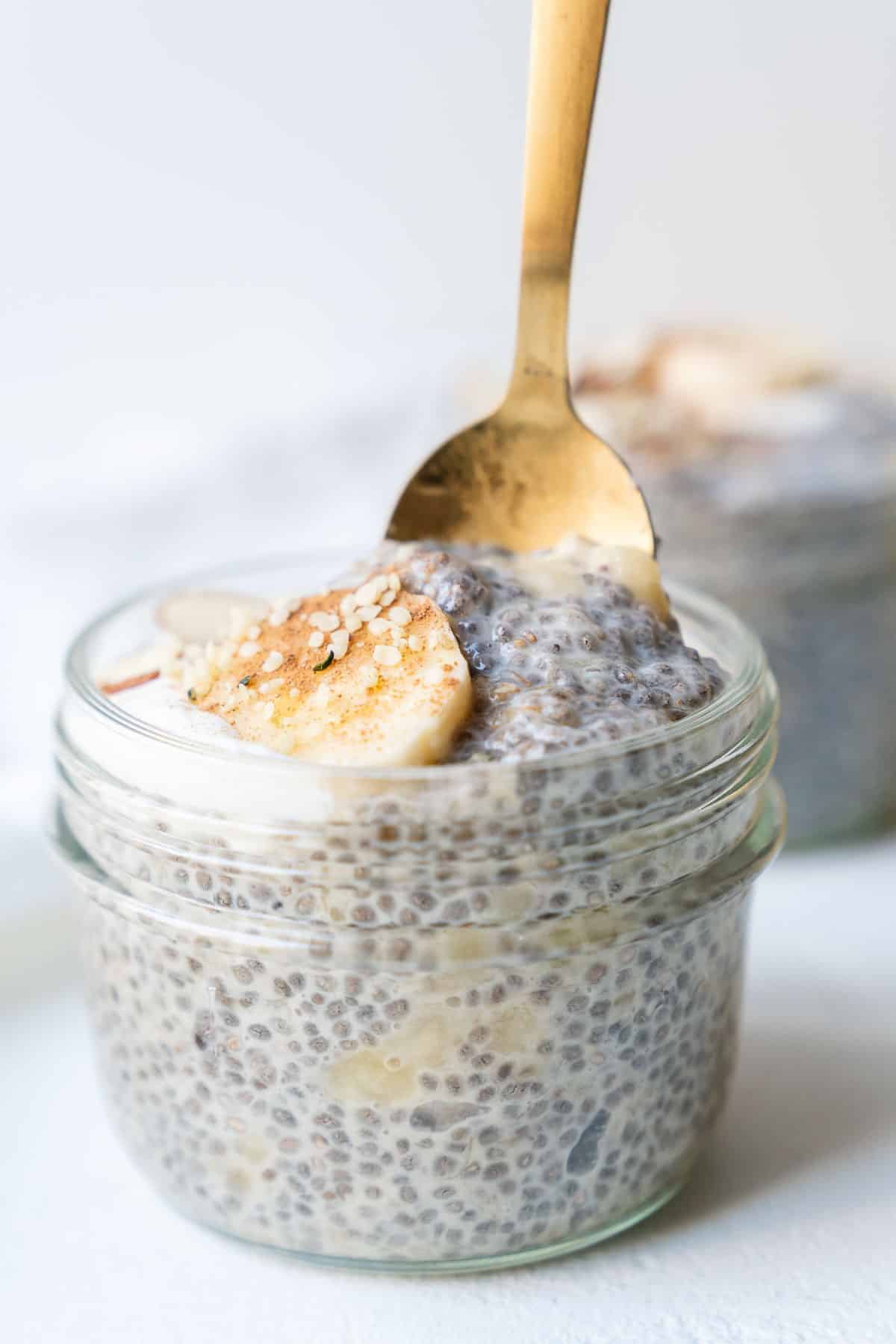 A side shot of chia pudding in a jar with bananas on top.